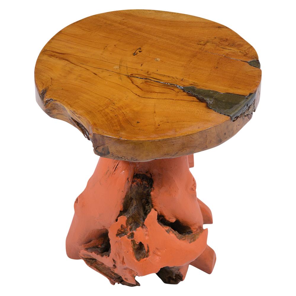 This fabulous root side table is crafted out of teak wood and has been newly stained in orange color with a varnish finish. This eye-catching piece has a beautiful freeform design and is ready to be used and enjoyed for years to come.