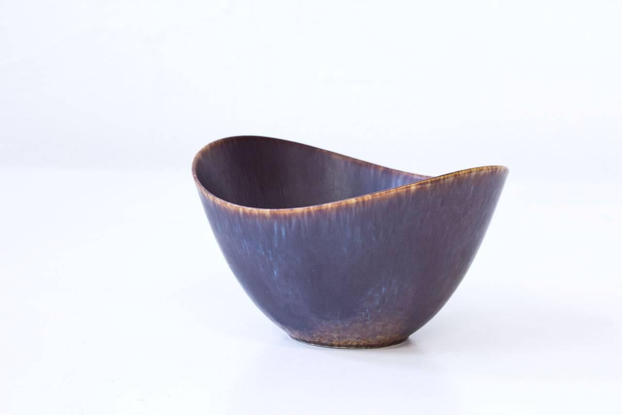 Organic stoneware bowl designed by Gunnar Nylund for Rörstrand, Sweden. Handthrown during the 1950s. Blue glaze with streaks of aubergine to brown. Signed
with initials of ceramist. 1st quality mark.