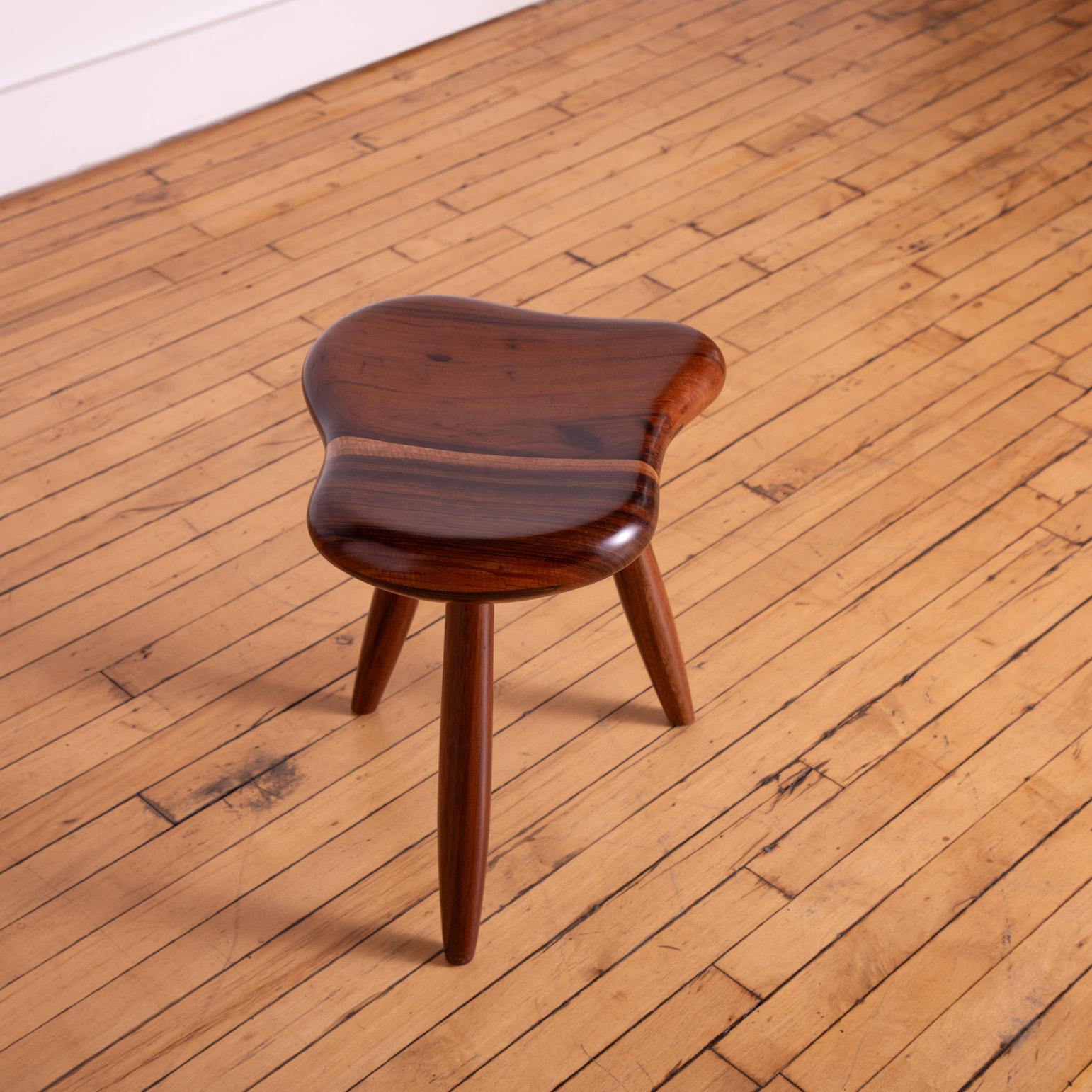 Tabouret asymétrique fabriqué sur mesure et sculpté de manière experte pour obtenir une forme unique rappelant celle du maître sculpteur Alexandre Noll. Pieds légèrement effilés. 

Bois de laurier sombre et expressif. 

Un véritable travail