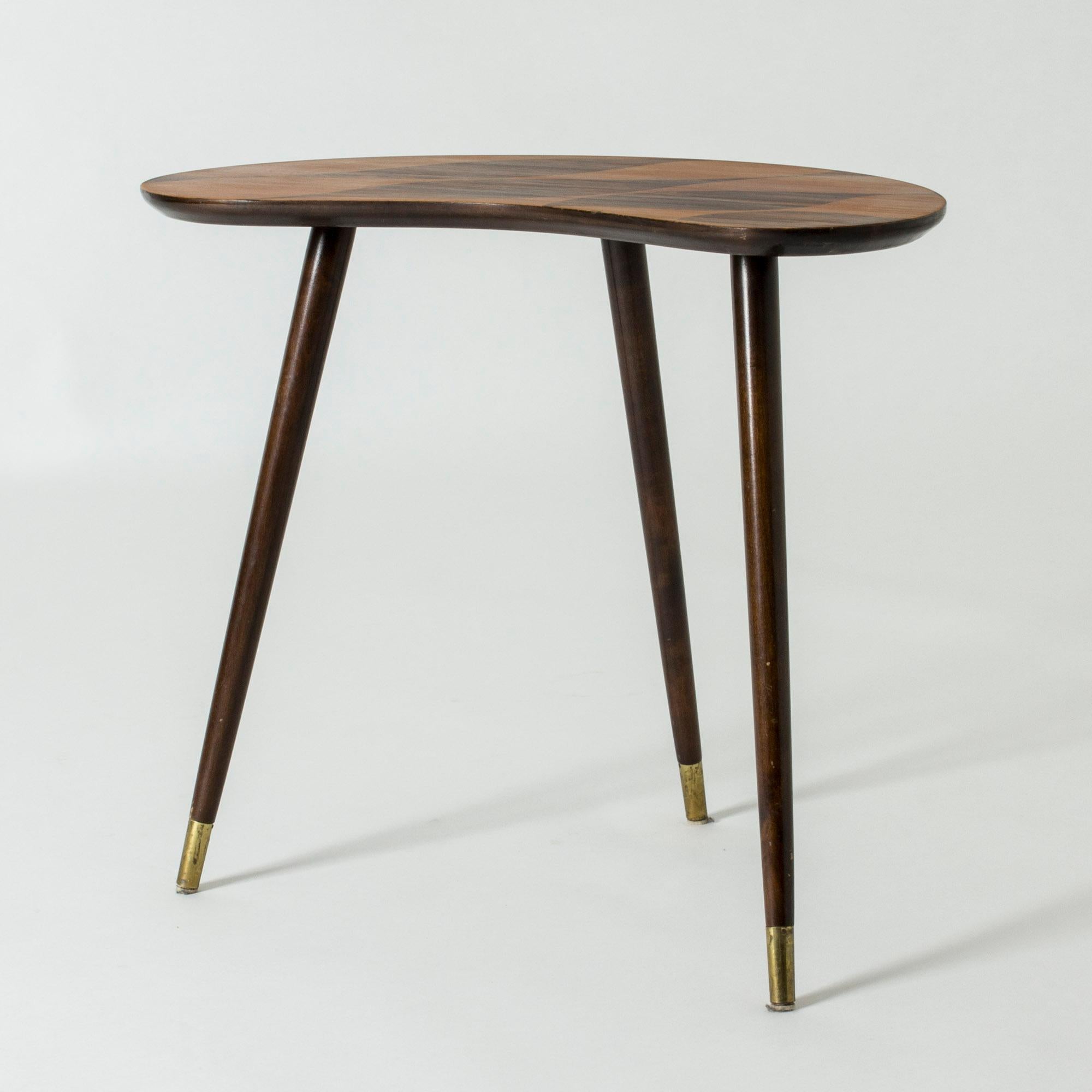 Lovely small occasional table, made in Sweden in the 1950s. Curved kidney-shaped tabletop with contrasting wood inlays in a graphic pattern. Three legs.