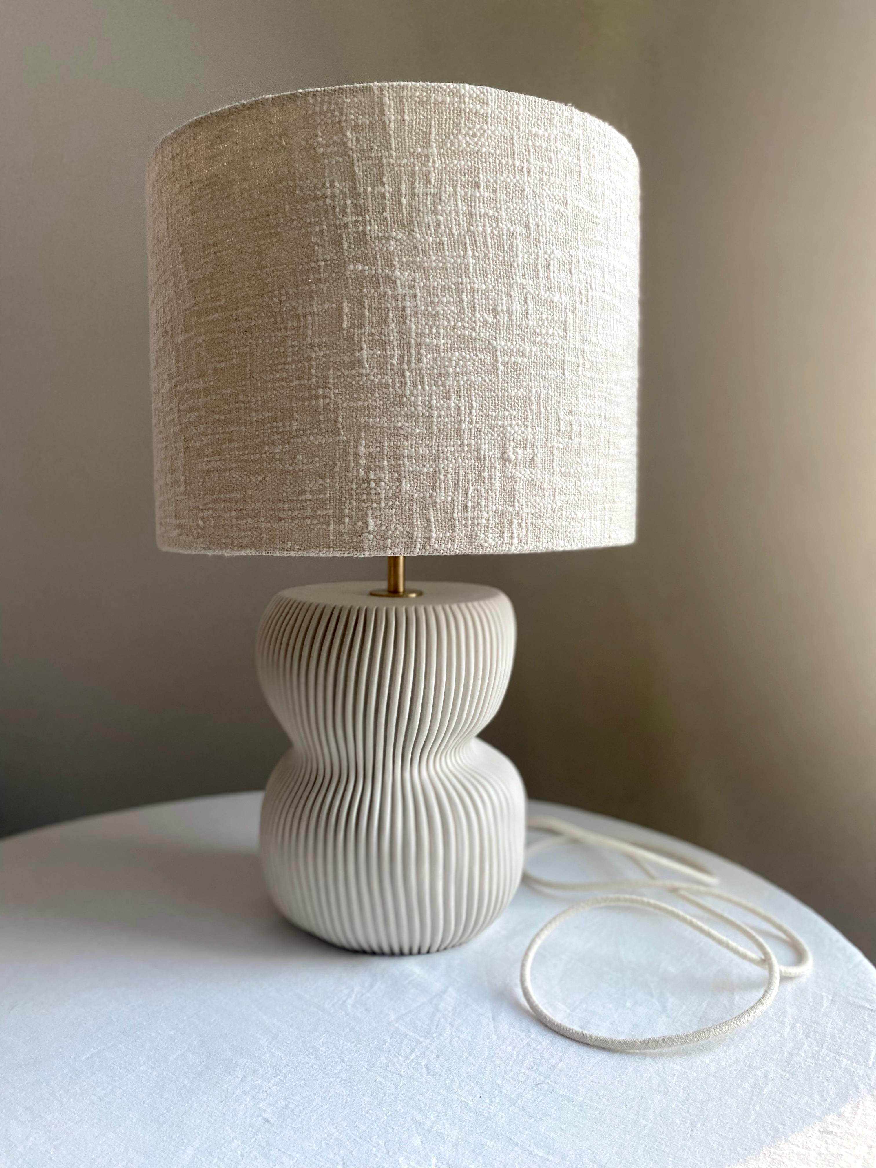 Handcrafted 'Organic Modern’ Table Lamp.

This sculptural table lamp is hand made from domestic porcelain, sculpted and carved using multiple techniques to achieve a vitreous, smooth finish.  
If you order a pair the dimensions and basic shape will