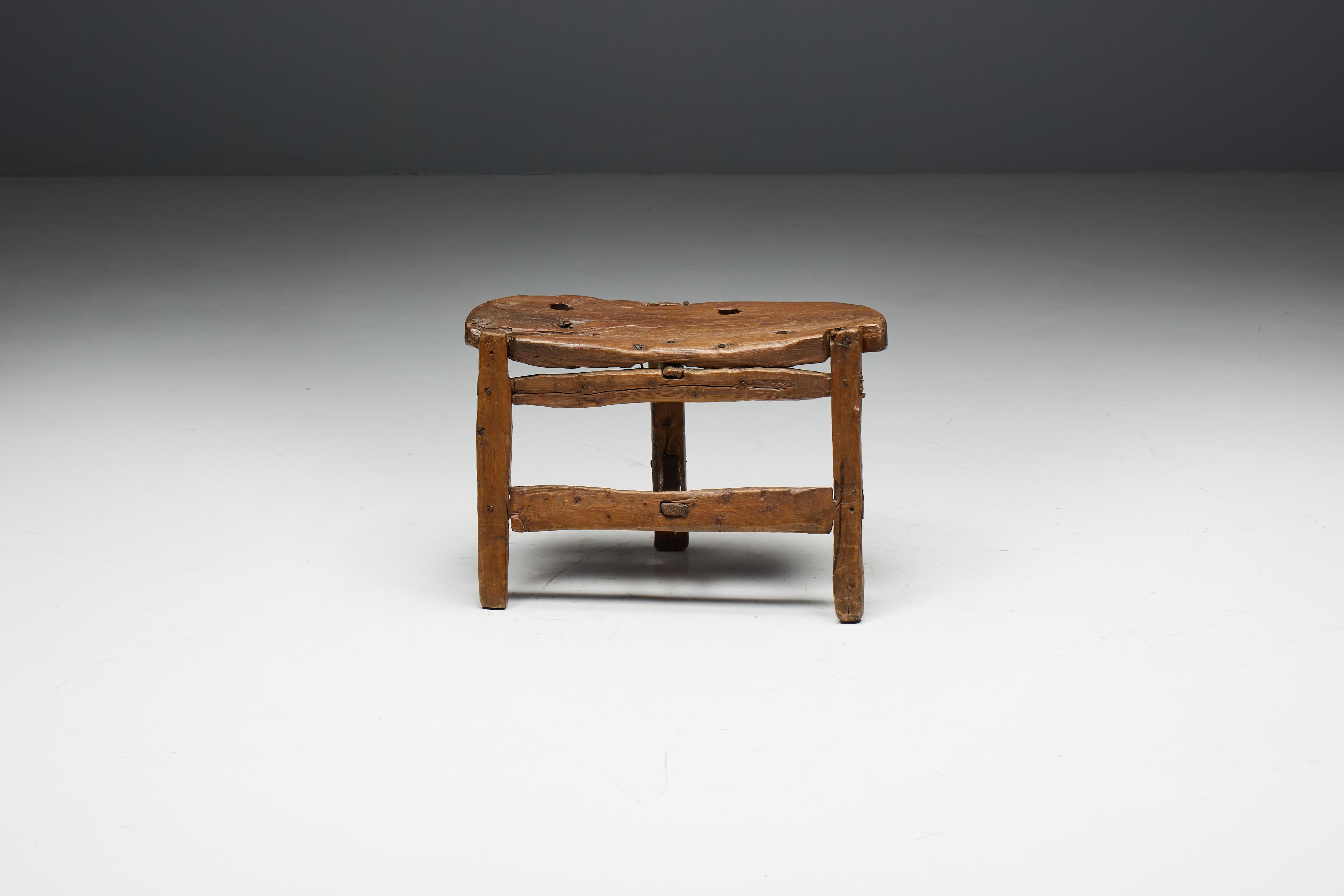 Organic tripod folk art bench that beautifully captures the essence of the wabi-sabi philosophy, a Japanese tradition that appreciates the beauty of natural imperfection and the grace of aging. Its remarkable patina and sculptural design highlight