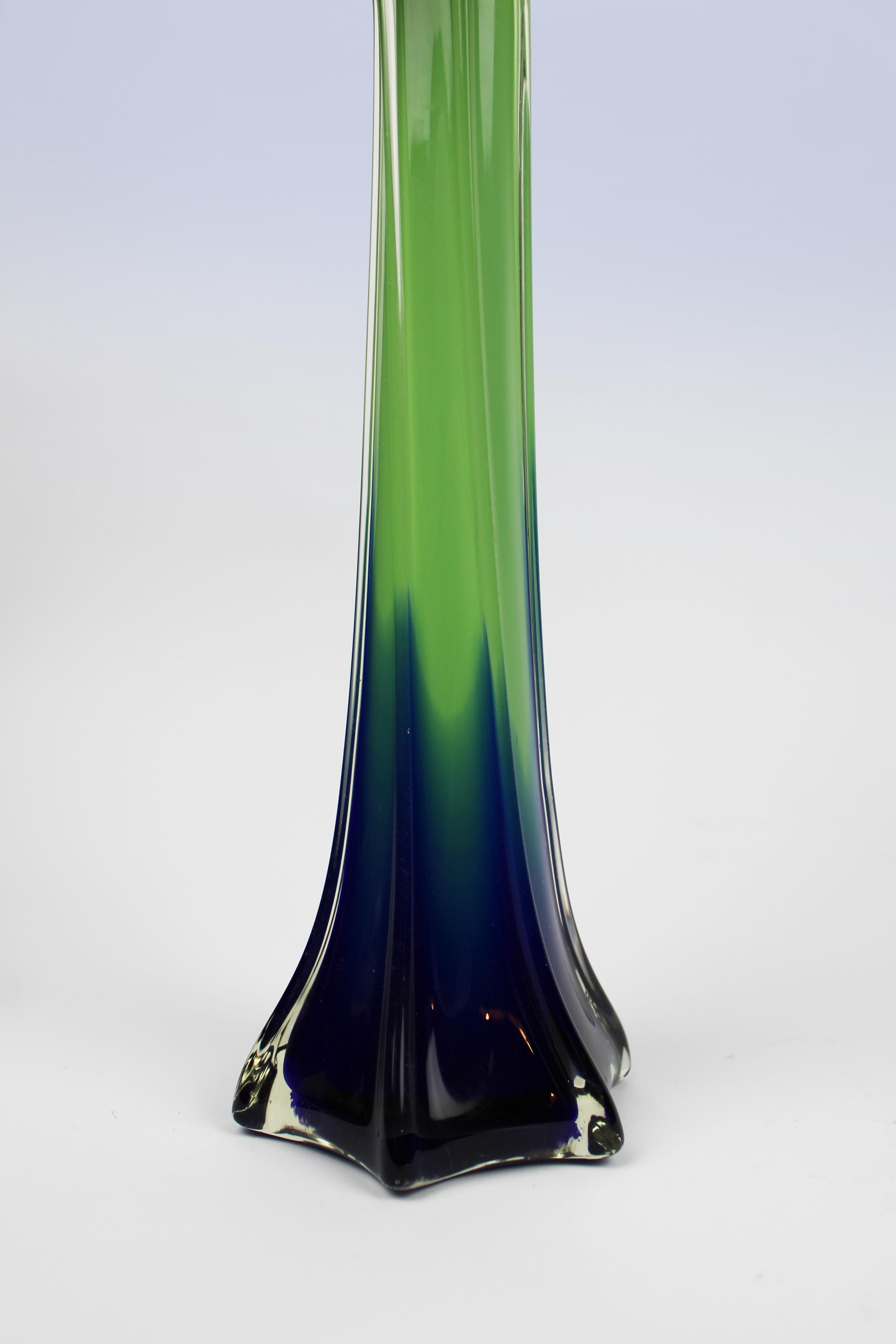 Introducing this exquisite organic vase, a rare masterpiece of Murano glass artistry. Featuring an alluring green and blue hue, it beautifully embodies the twisted flower design known as 