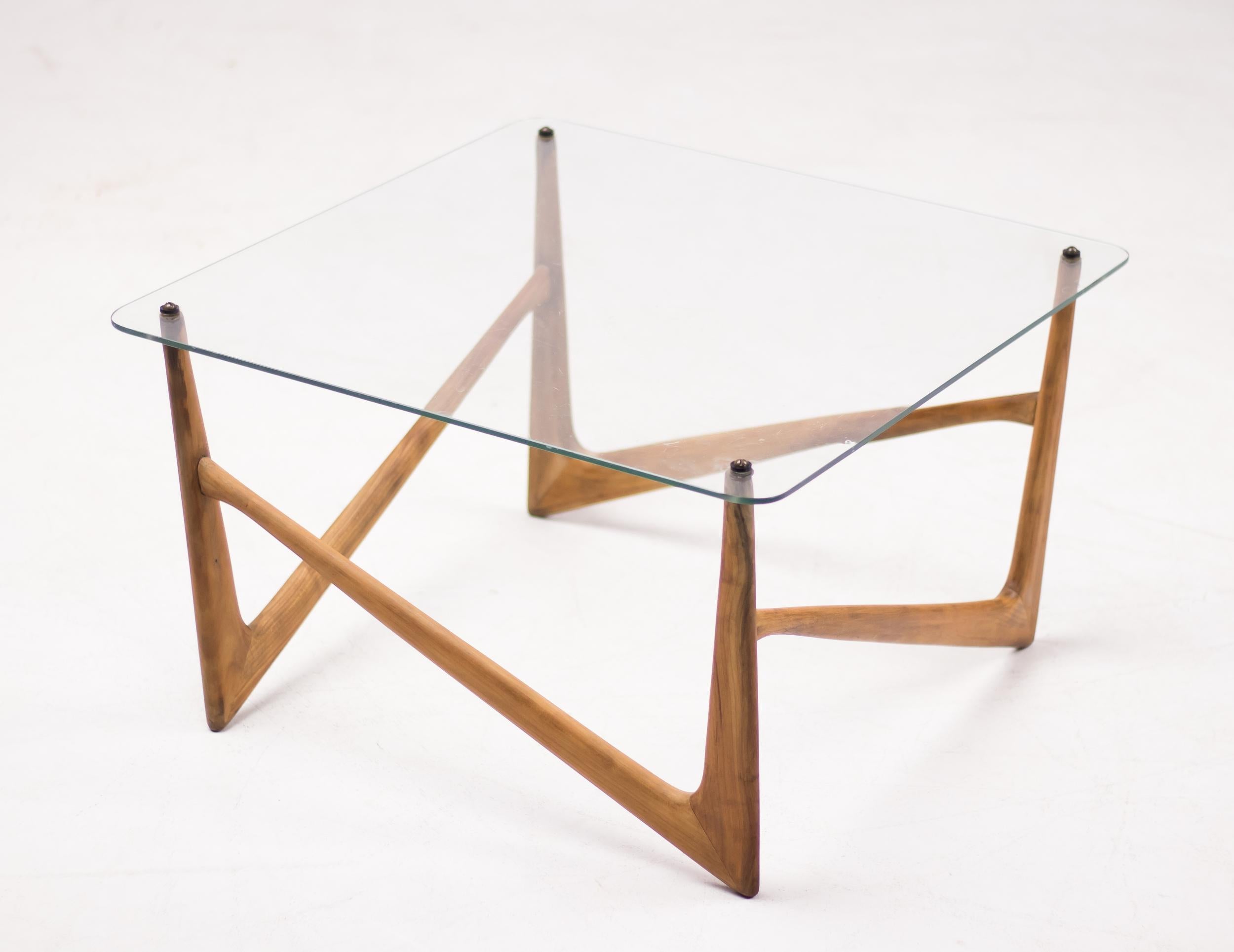 Elegant Italian Mid-Century Modern coffee table with a carved solid walnut base and crystal glass top.
The sculptural quality of this beautiful table resembles the organic designs of Carlo Mollino, Isamu Noguchi and Eero Saarinen.
The bone-like