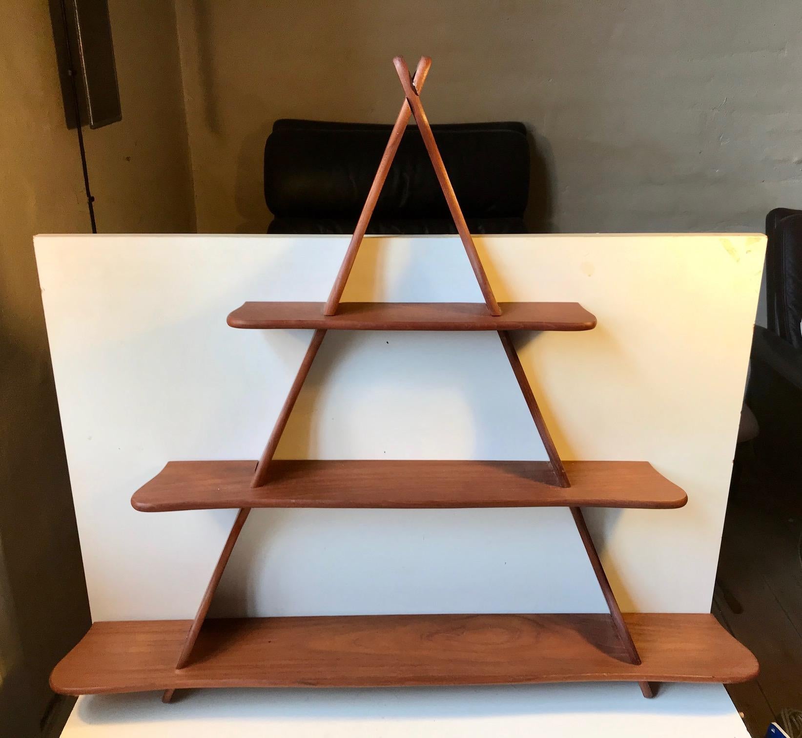 Triangular shelving unit with rounded profiles designed by Peder Moos in collaboration with his students at the architect’s school in Copenhagen. Suitable as spice rack or for display of small collectibles. It is assembled without the use of