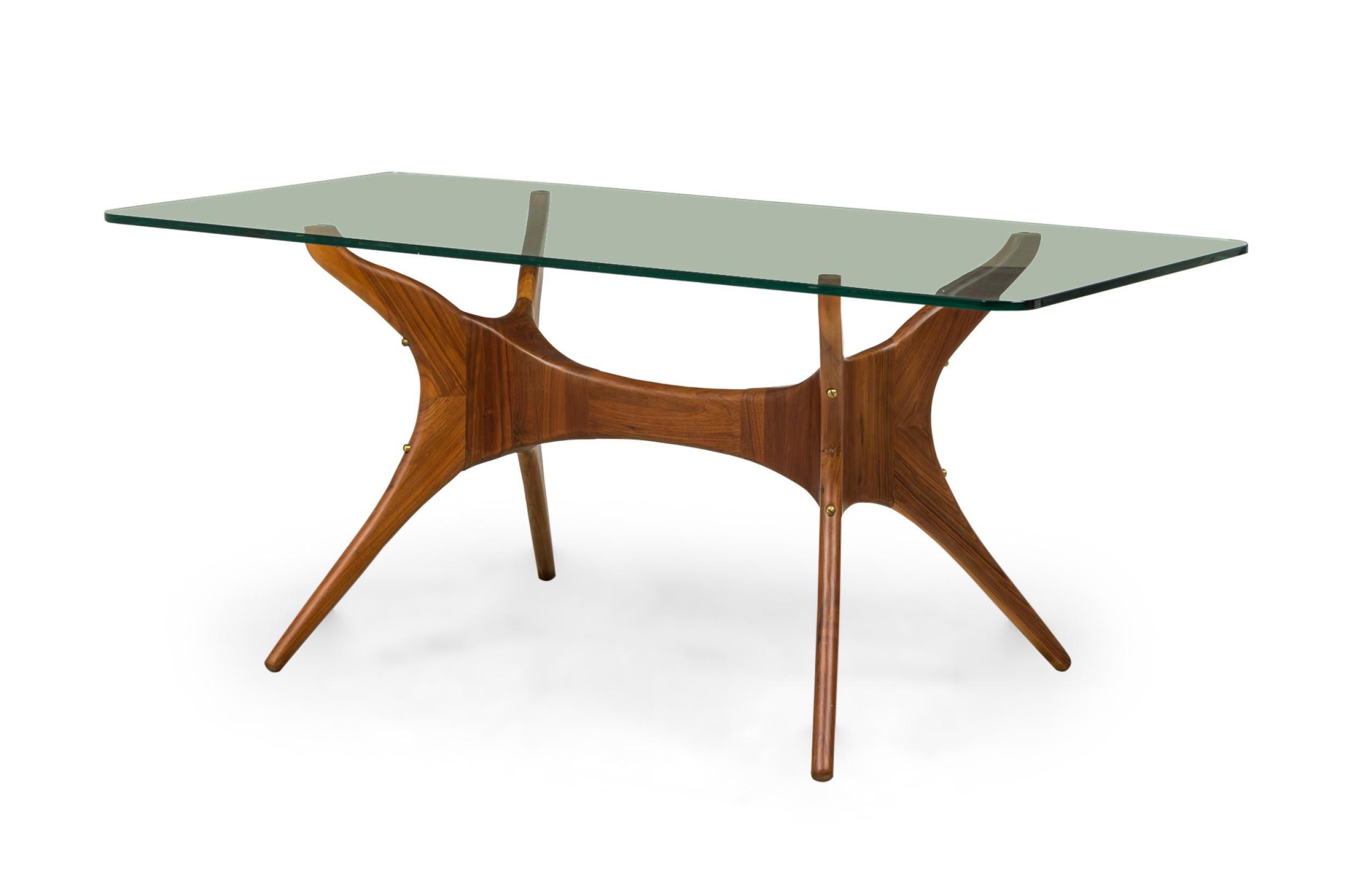 Contemporary rectangular Dining Table constructed of solid walnut with tempered glass top and brass screw details.