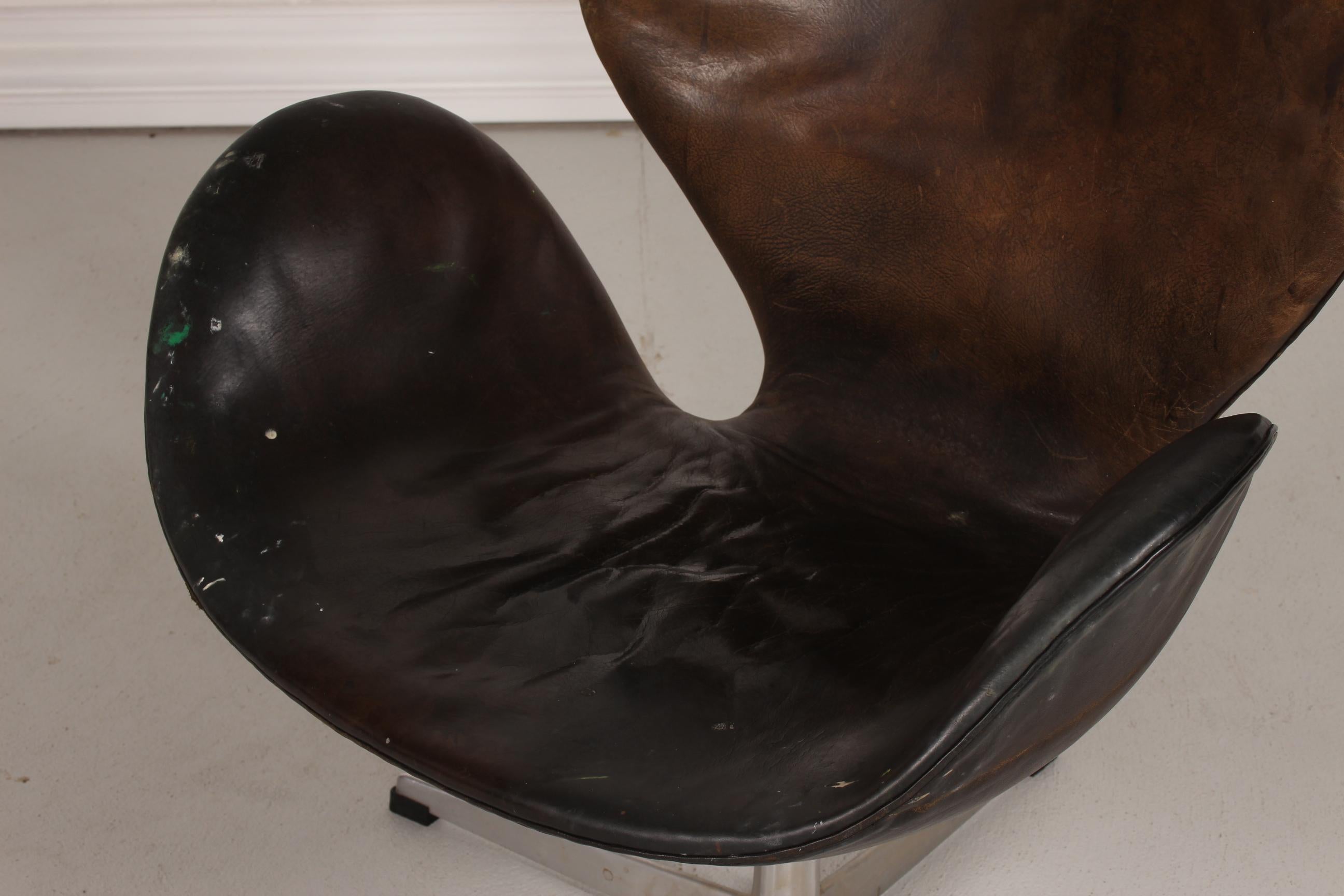 Here is a unique Swan chair model 3320 from the 1960s.
It's upholstered with black leather with great and heavy patina and spots from paint.
The previous owner was an art painter and the Swan was a part of his studio for decades.
The foam under