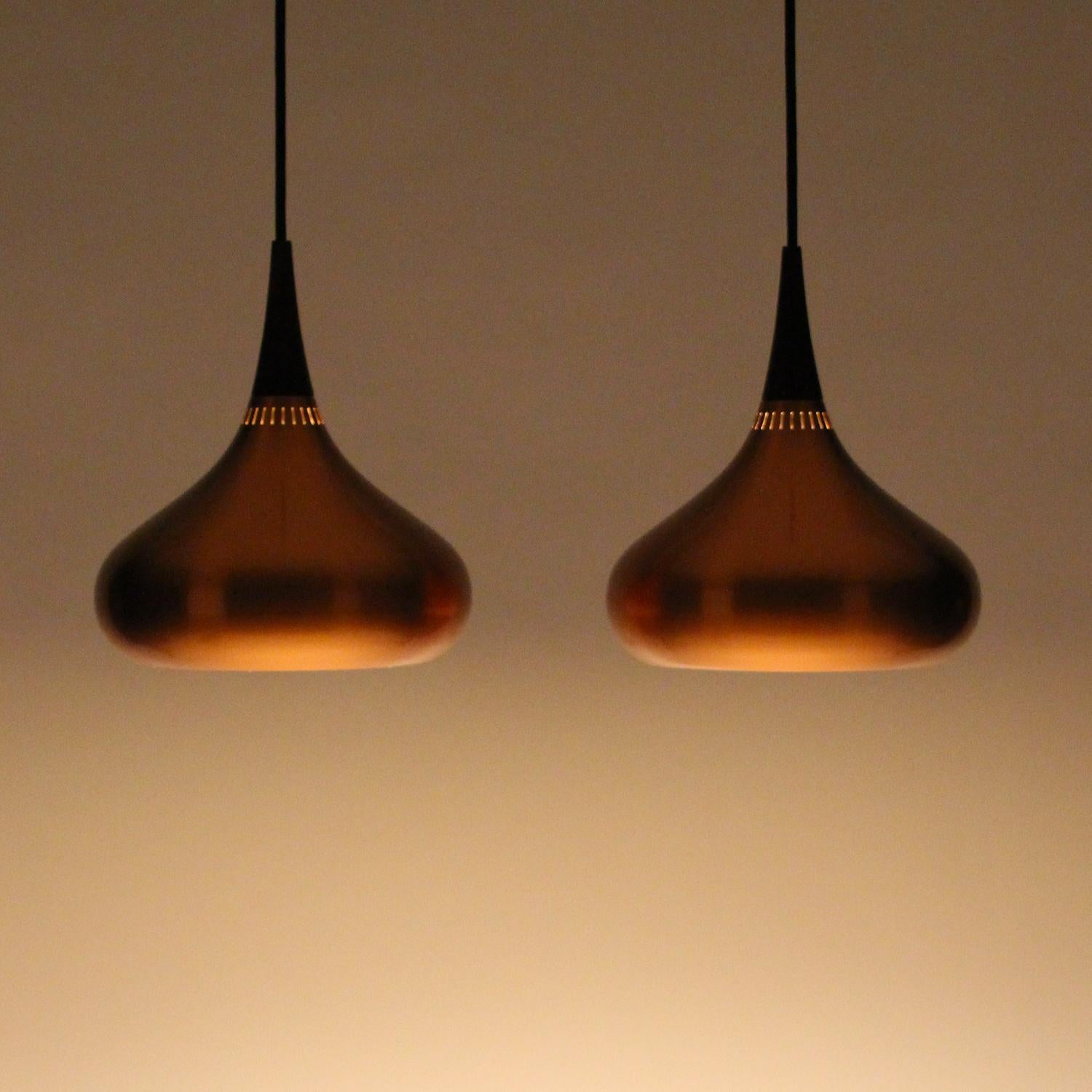 Orient Minor copper pendant pair by Jo Hammerborg for Fog & Mørup in 1963 - super attractive pair of copper lamps with rosewood tops, in very good vintage condition.

An attractive pendant pair made in solid copper with teardrop-shaped shade and a