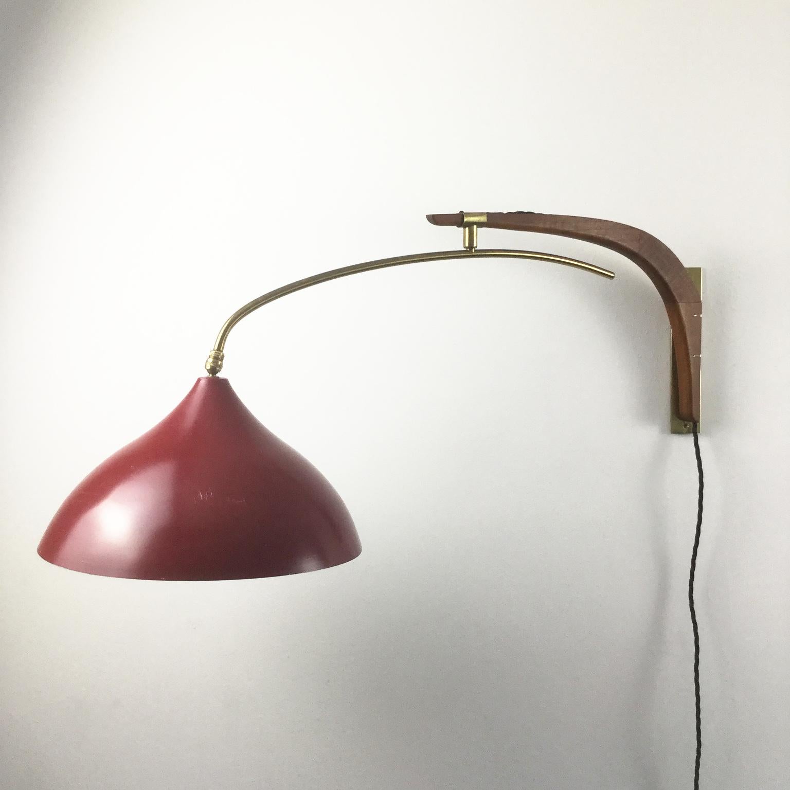 An orientable wall lamp by Svend Aage Holm Sorensen (1913-2004) in teak, brass, red and white lacquered metal edited by Holm Sorensen.