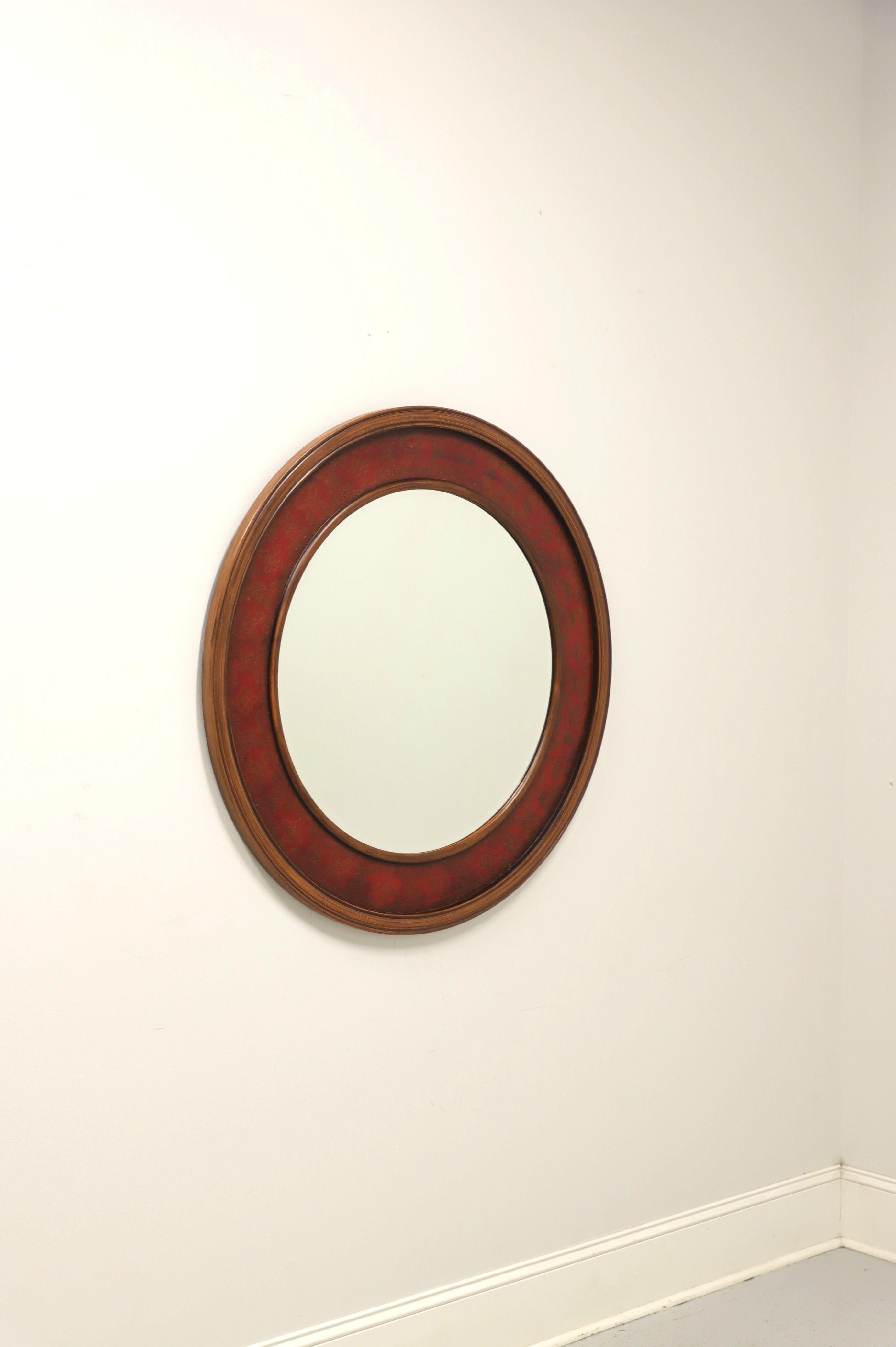 An Asian Chinoiserie style round wall mirror by Oriental Accent. Beveled mirror glass in a round wood frame with a middle circle of hand painted red & bronze decorative Chinoiserie and an inner & outer circle of walnut colored wood. Made in Asia, in
