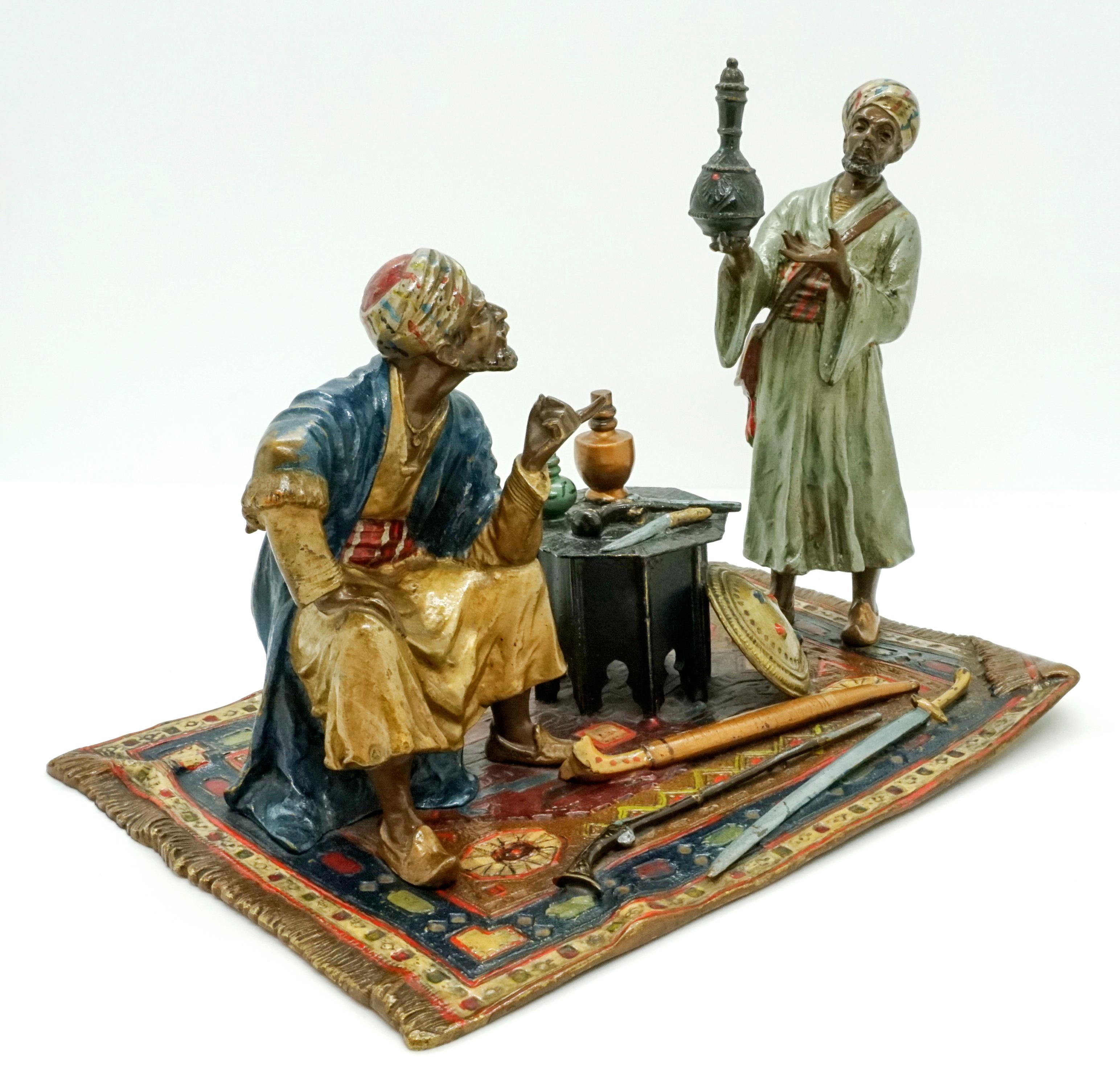 Excellent piece of Viennese bronze Art of 1900

Two Arabs in long robes and turbans talk shop over an oriental, bottle-like vessel. On the little table between the two there are more bottles and antique weapons: a knife and a pistol, in front of