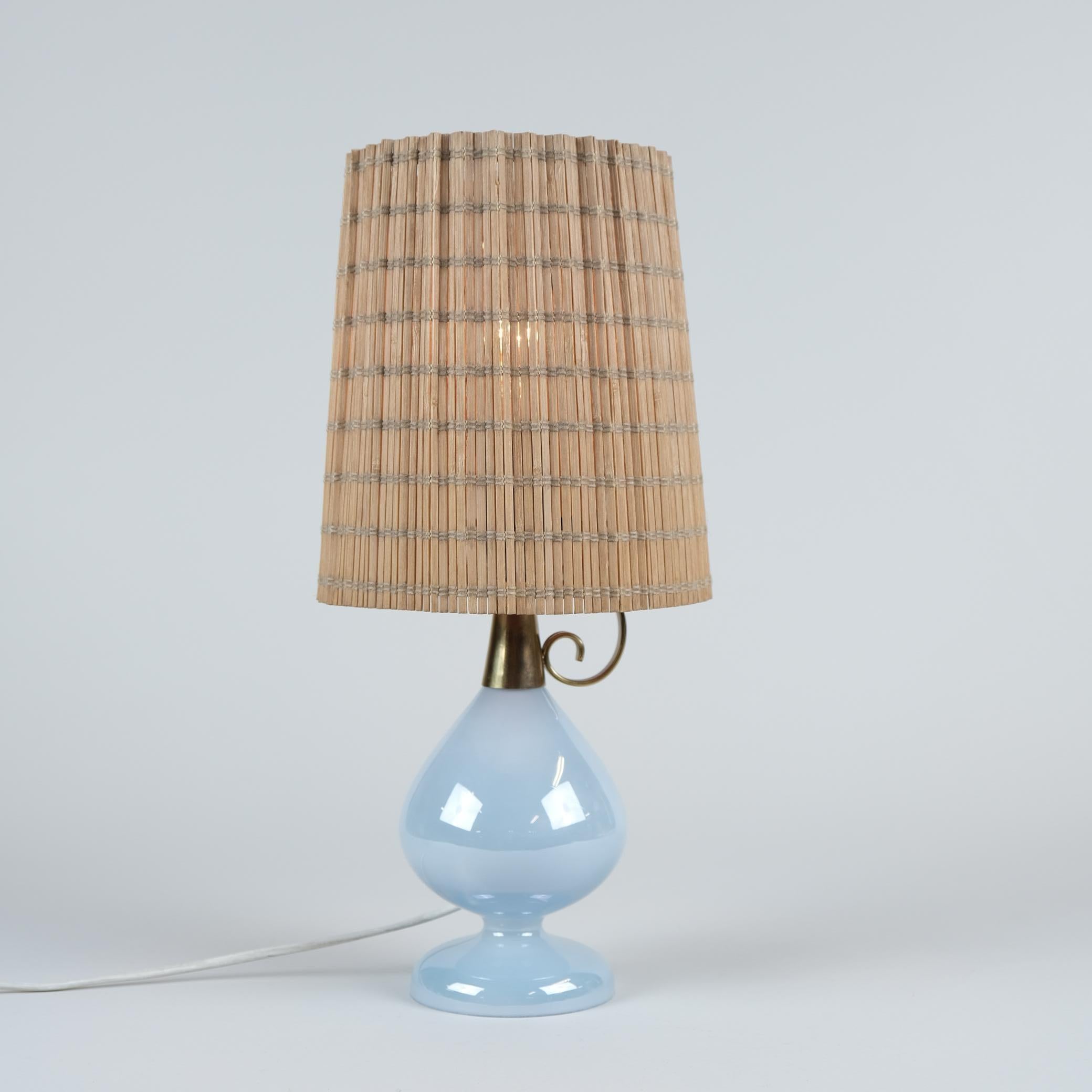 Una delicada lámpara de mesa de estilo oriental modelo K11-18 de Maria Lindeman para Idman de la década de 1950. Esta rara lámpara, casi como un farol de Aladino, tiene una base de vidrio soplado azul con una parte superior y un asa de latón. La