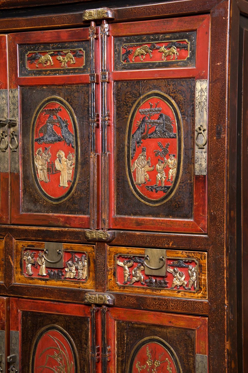 Wardrobe with two bodies with doors up and down, flanking four drawers, decorated on the front with figurative motifs of strong oriental influence and metal fittings. Both in the structure and in the decoration and the chosen colors (predominance of