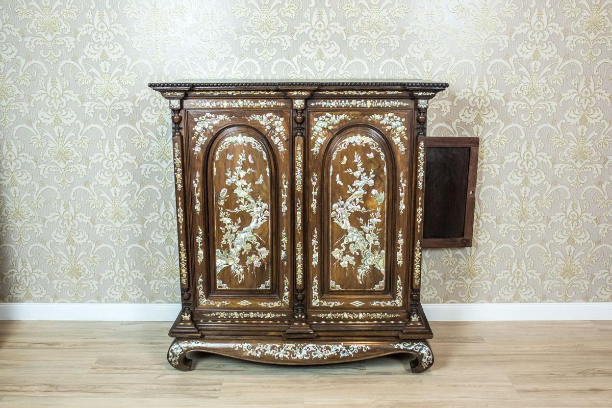 We present you this antique piece of furniture, circa 1900, probably manufactured in China for the European market.
The cabinet is composed of a base with legs characteristic for eastern furniture and an upper section with false door.
The inside