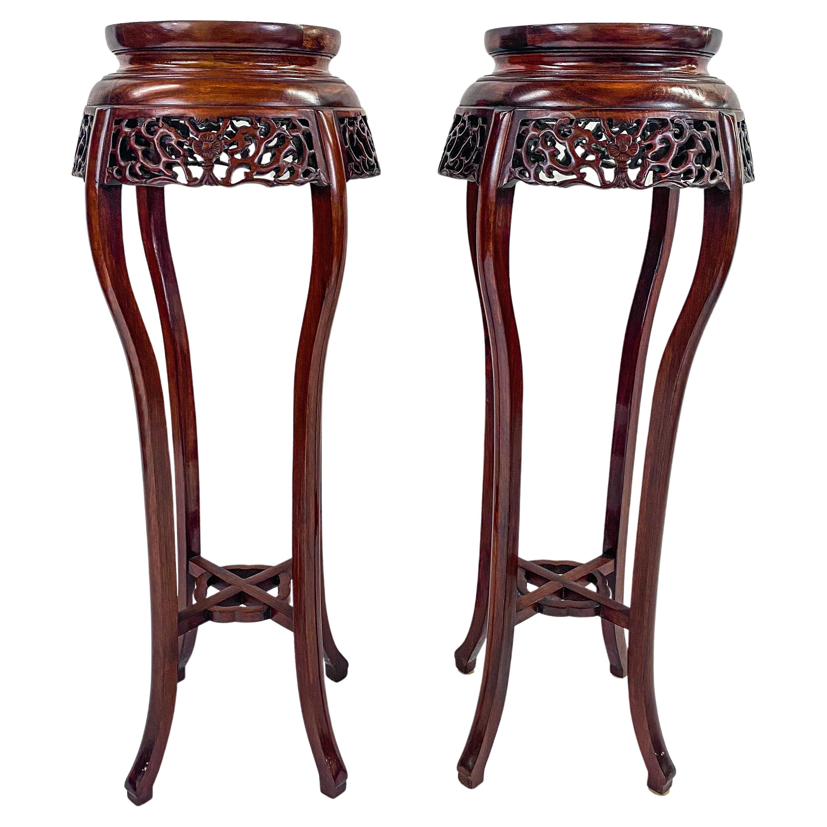 A classy pair of hand-carved Rosewood Chinese Oriental plant stands or pedestals. The aprons are embellished with floral design carving and the legs are beautifully curved with the circular top featuring green malachite adding style to this rare