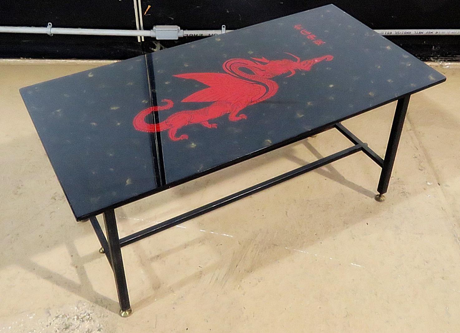 Oriental smoked glass top coffee table with a dragon design on a metal frame with brass feet.