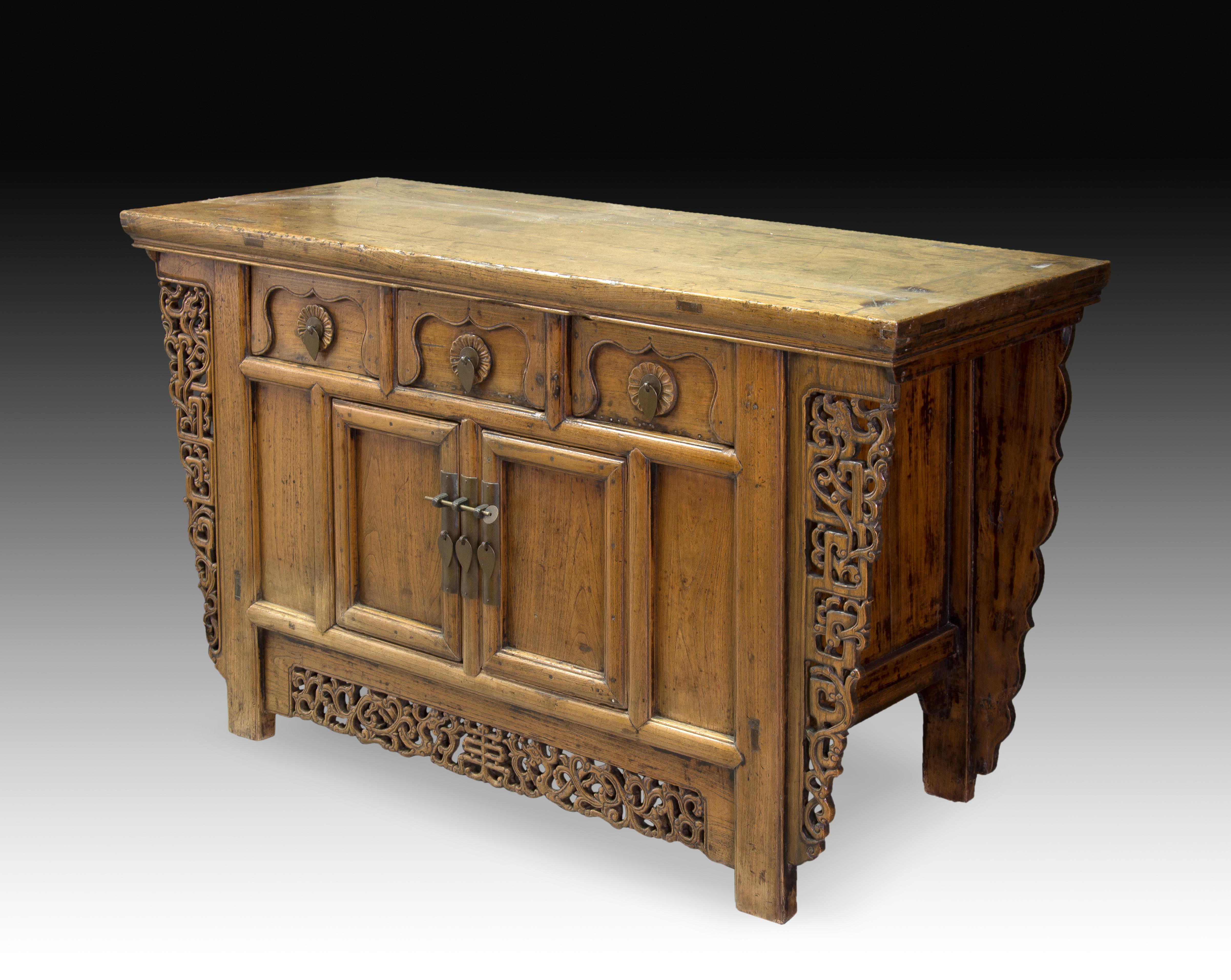 Console rectangular straight board decorated on the front with an openwork composition based on geometric and vegetable motifs of Chinese influence, which has three drawers on the top decorated with floral shapes and corrugations and two doors to