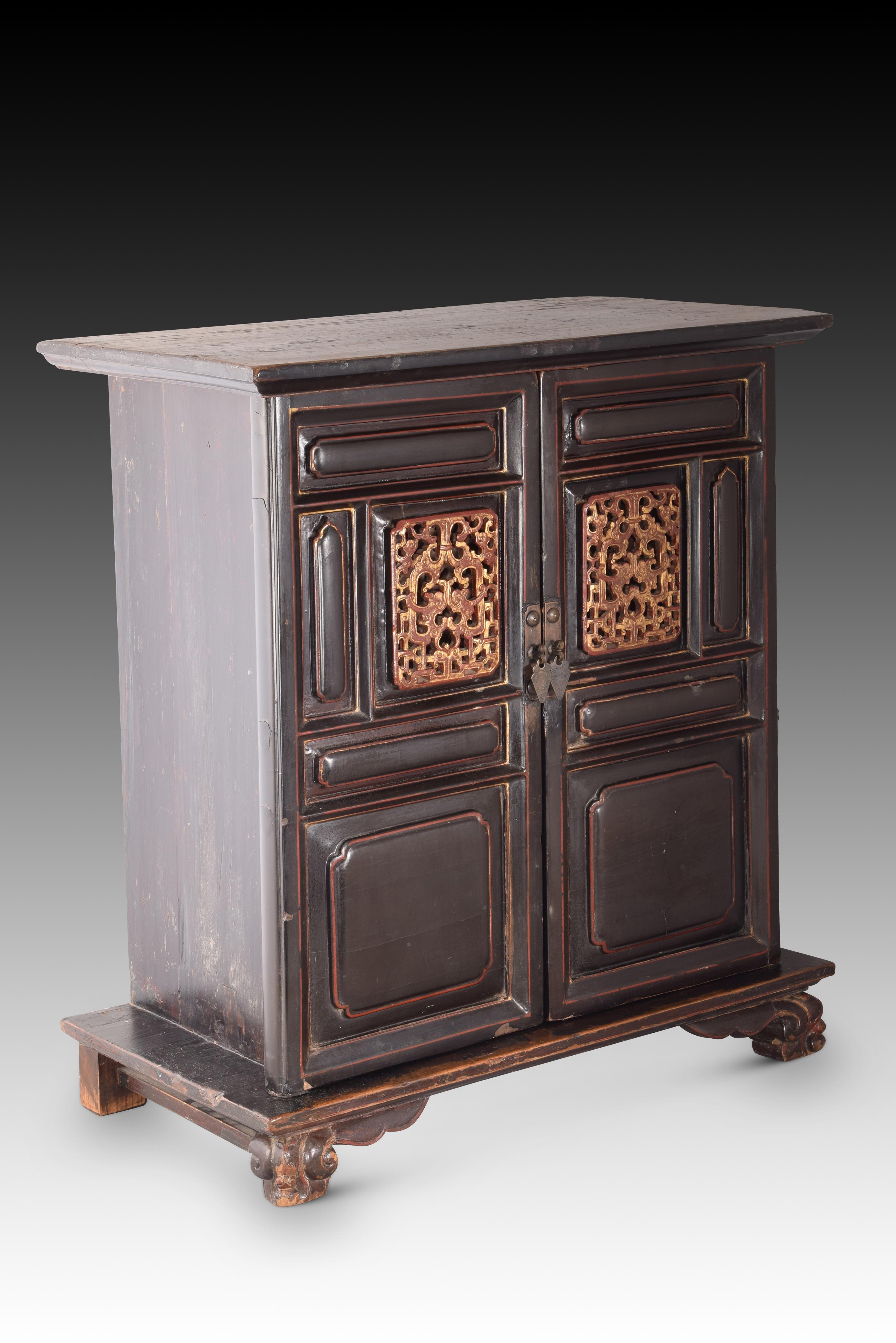 Eastern box office. Carved wood, metal. XIX century. 
Wooden block on legs (the front ones are carved) that has two doors at the front with metal handles and a decoration based on panels combined with two panels of simple openwork geometric motifs