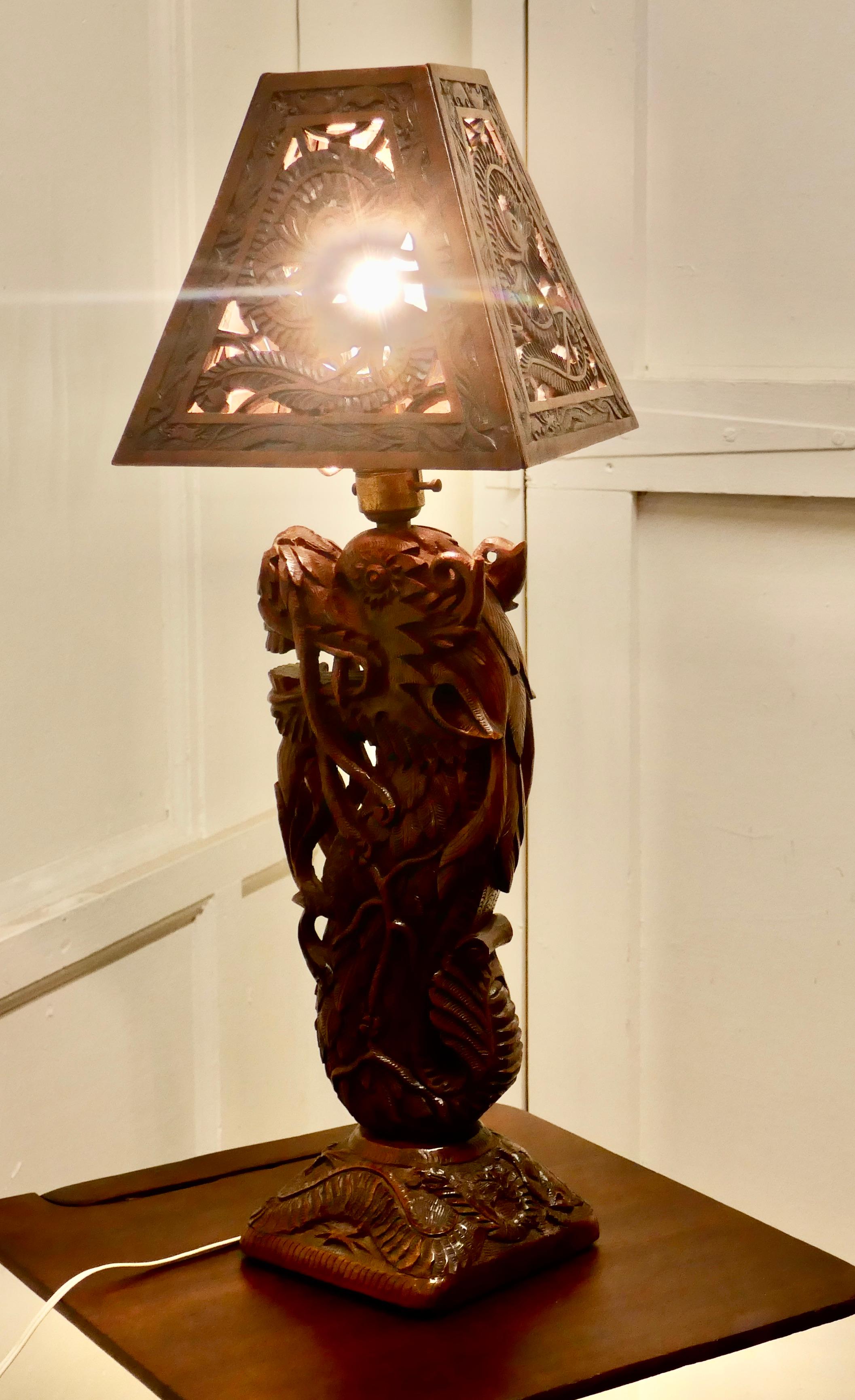 Oriental Folk Art Carved Teak Dragon Lamp 

This is superb piece of hand carving, the base of the lamp is in the form of a Fierce Water Dragon and the shade too is made in wood and carved with Serpent Dragons in such a way that the light can shine
