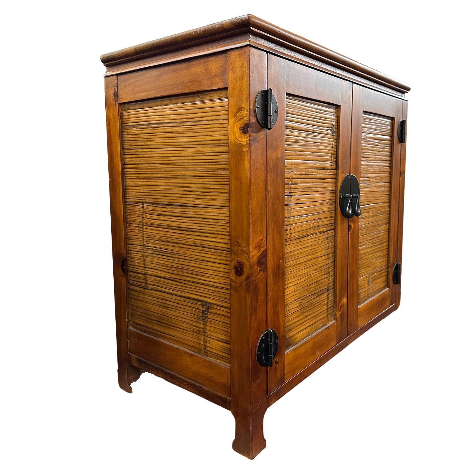 The oriental style reminiscent of designer James Mont with Koa wood and rattan cabinet seamlessly fuse traditional craftsmanship with contemporary design. Crafted from quality wood and adorned with intricate rattan detailing, it offers ample storage