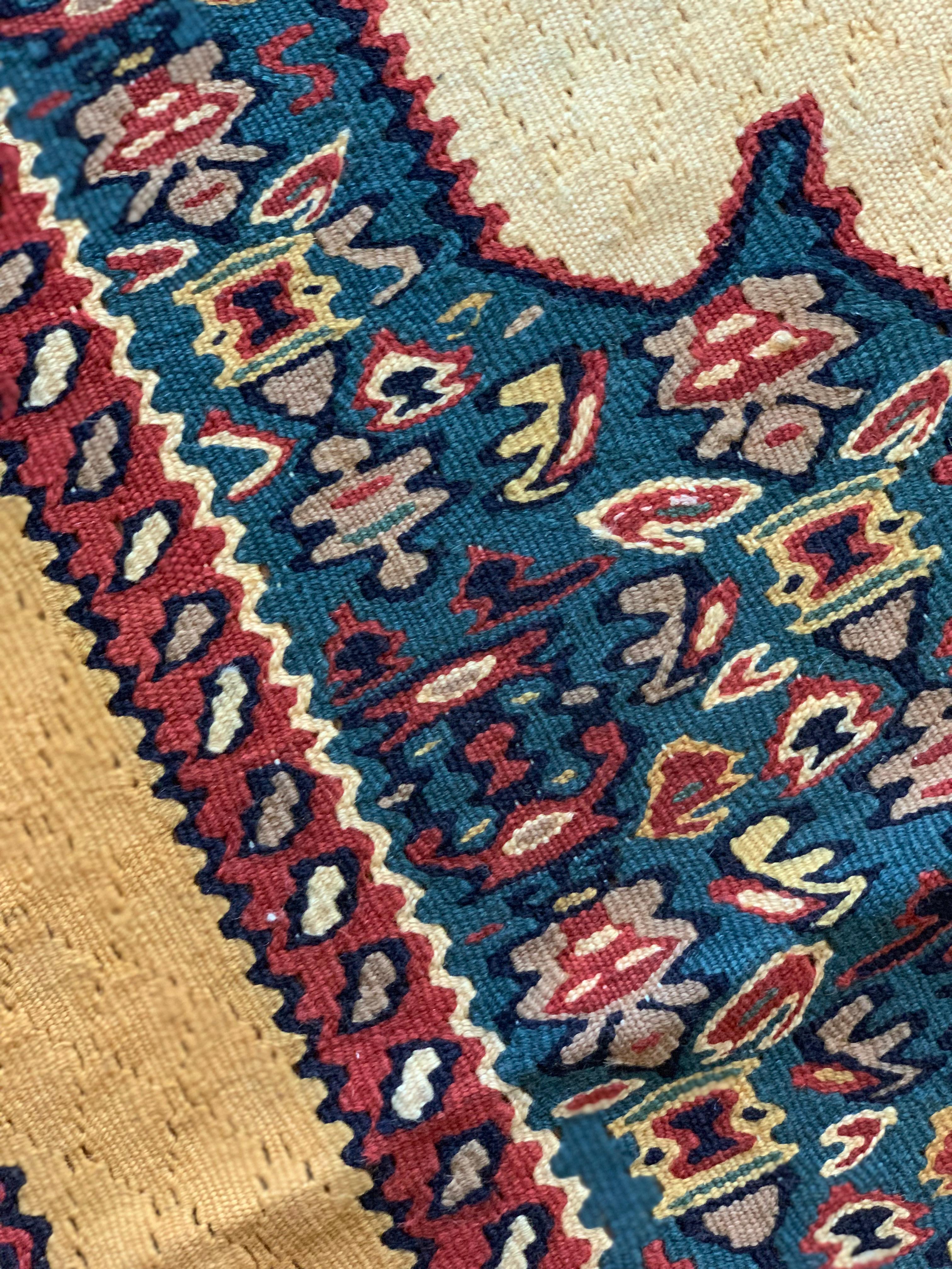 This beautiful wool carpet is a handmade, flatwoven kilim woven in the early 21st century, circa 2010. It is unused and so is in excellent condition. The design features a bold medallion design woven on an ivory background with blue, brown and cream