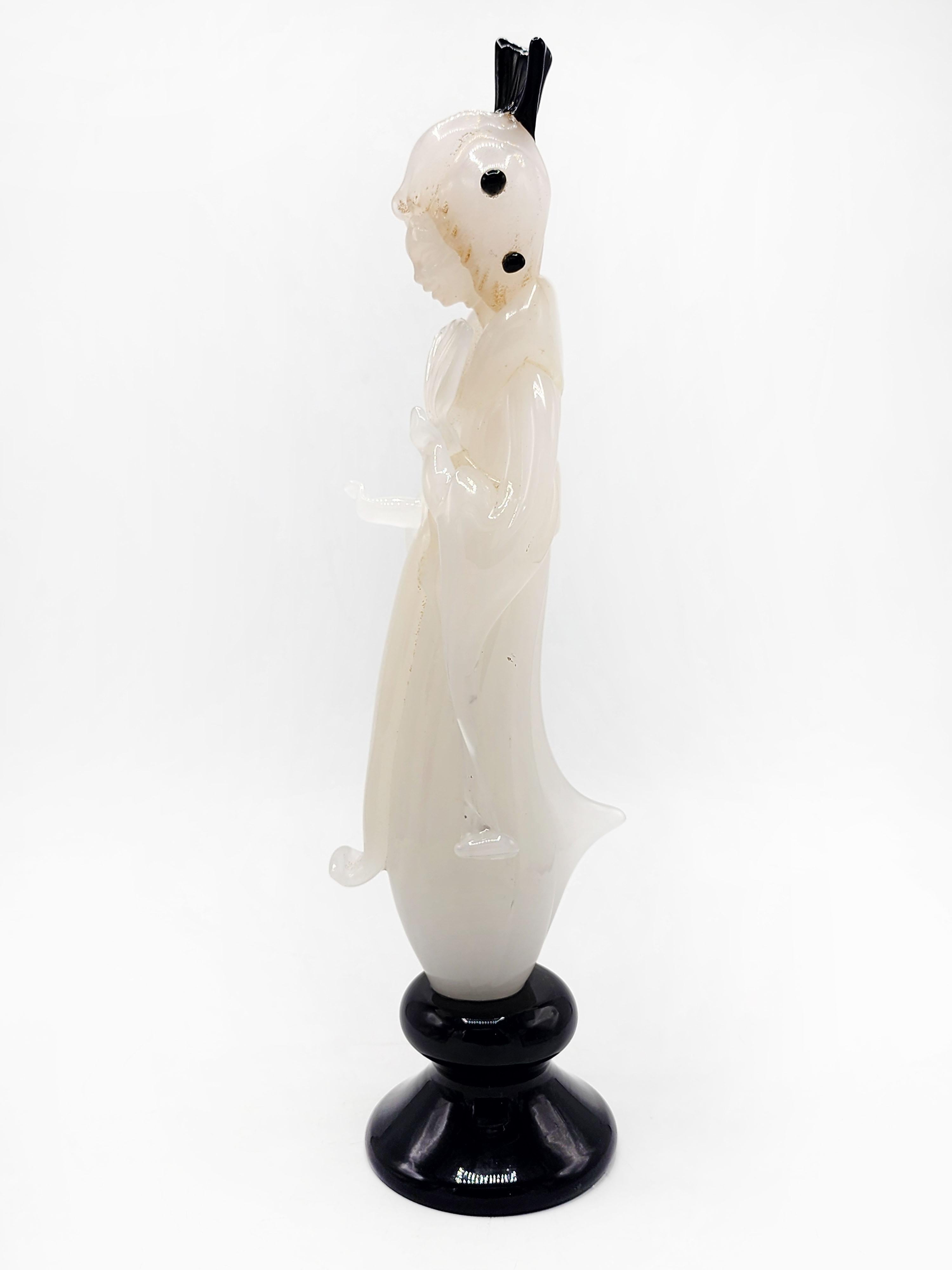 Figurina di donna orientale in vetro di Murano
Bellissima figura in vetro italiano, di Murano, di una dama orientale color crema, con dettagli neri sia sulla base che sulle decorazioni dei capelli e con dettagli in glitter oro.
Misure:
Altezza: 41.5
