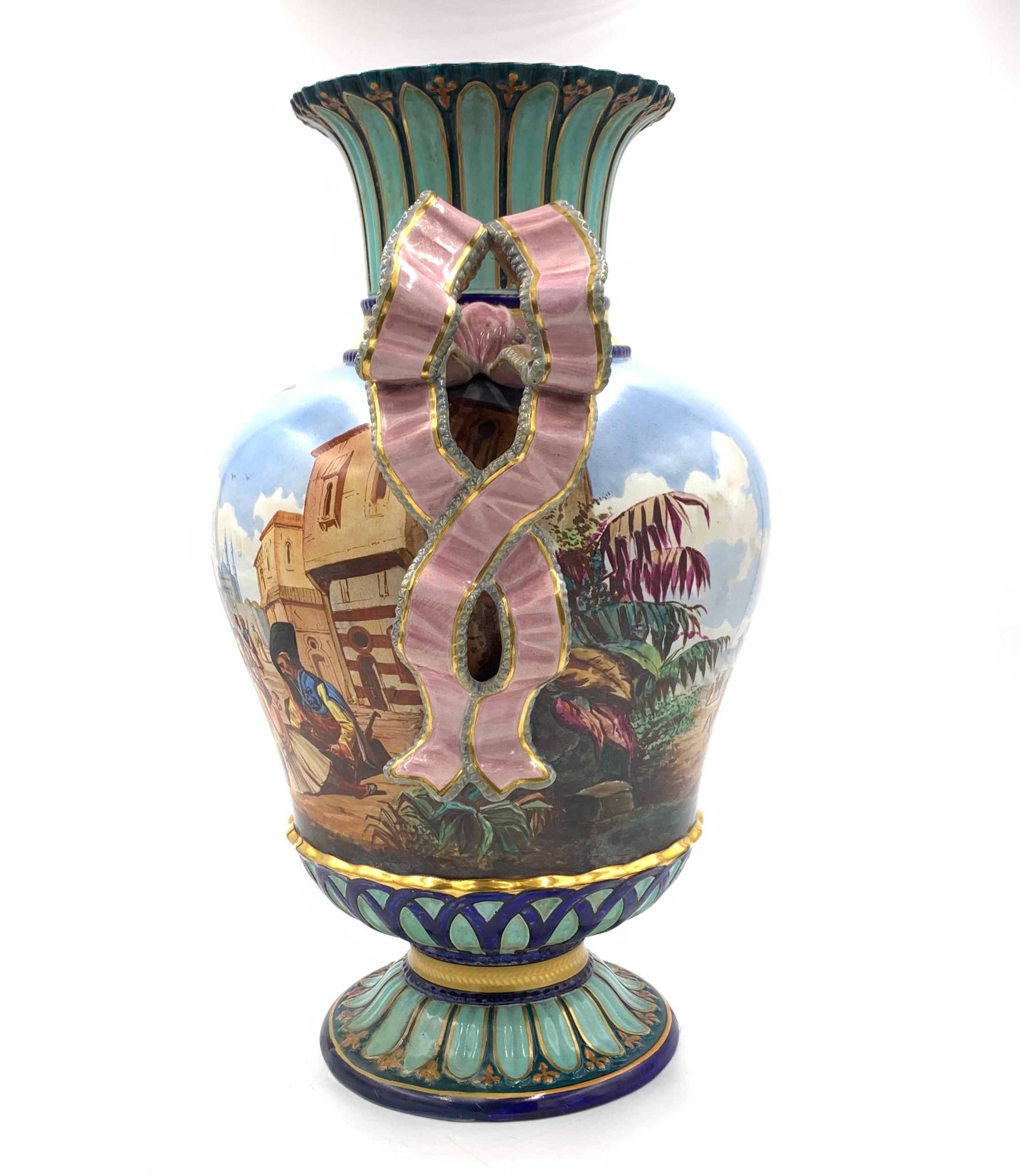 The front of the ovoid body depicts Arab men speaking with a women in the market surrounded by building and mosques while the reverse of the vase depicts a horseman in an empty land surrounded by palm trees. 

