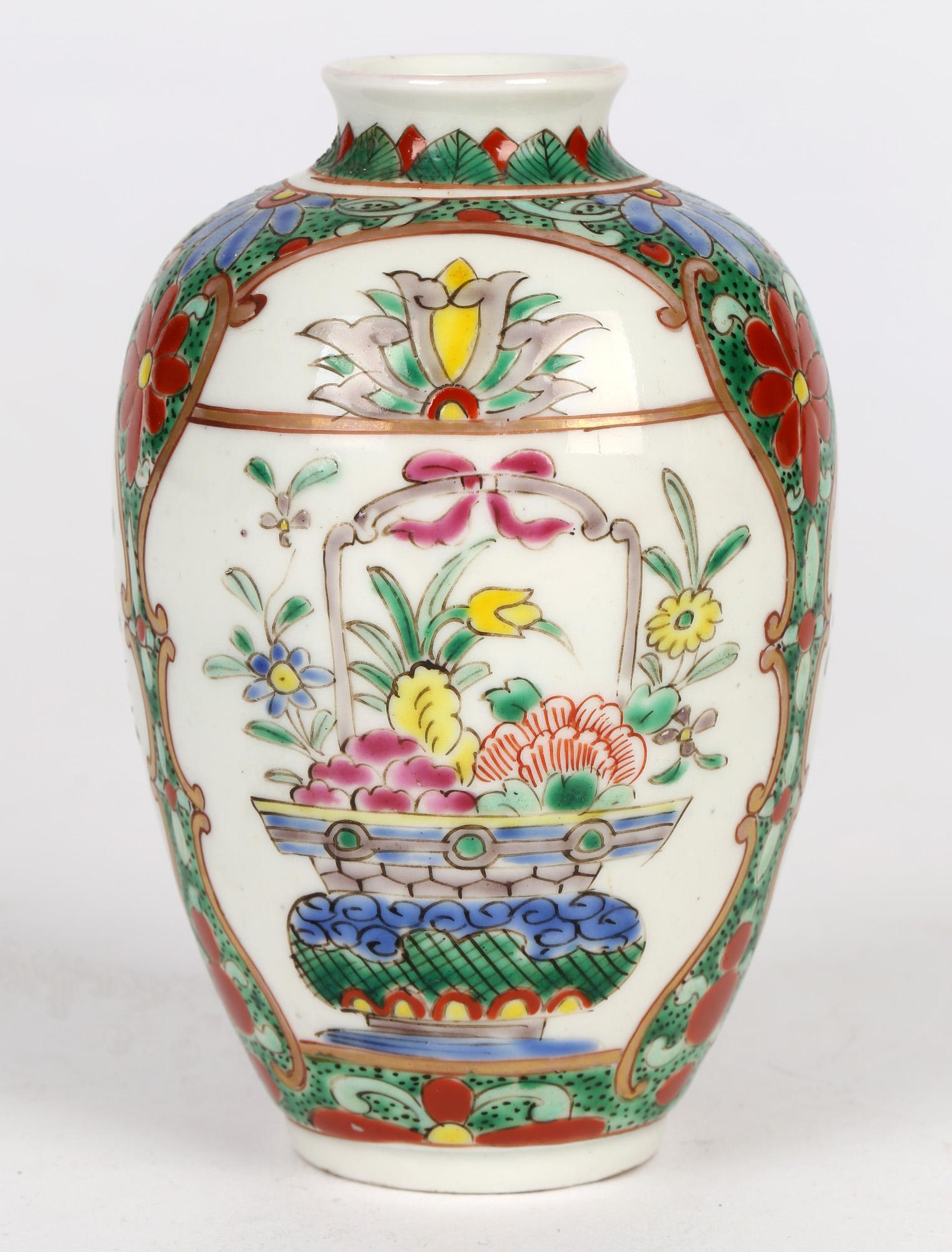 A very finely made oriental styled porcelain vase hand painted with baskets containing flowers dating from the late 19th or early 20th century. The bulbous shaped vase stands on a narrow rounded foot and is hand decorated in coloured enamels with