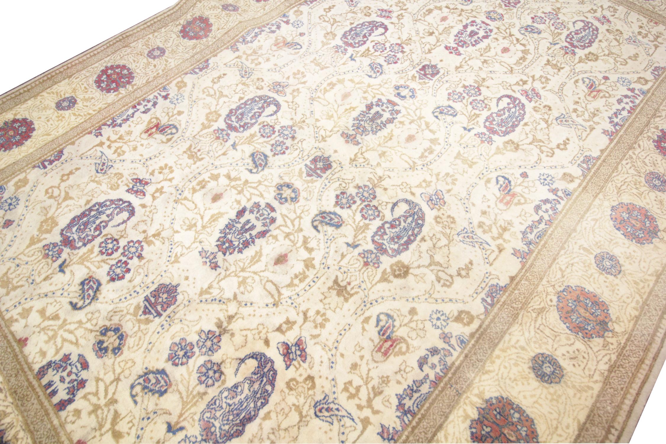 Beautifully handwoven patterns of floral and paisley designs sit on a background of cream and beige to create this stunning all-over design area rug. This vintage rug has been handmade carpet by Turkish artisans, made with handspun wool, which has