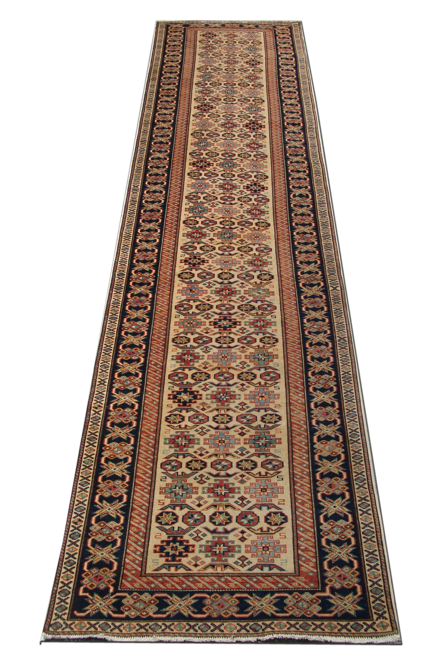 This new traditional handwoven rug is an example of a geometric rug that comes in a striking color combination. The bright red, green, navy, dark blue, sea blue, ivory, and caramel colors look magnificent with this elegant cream rug. The border of