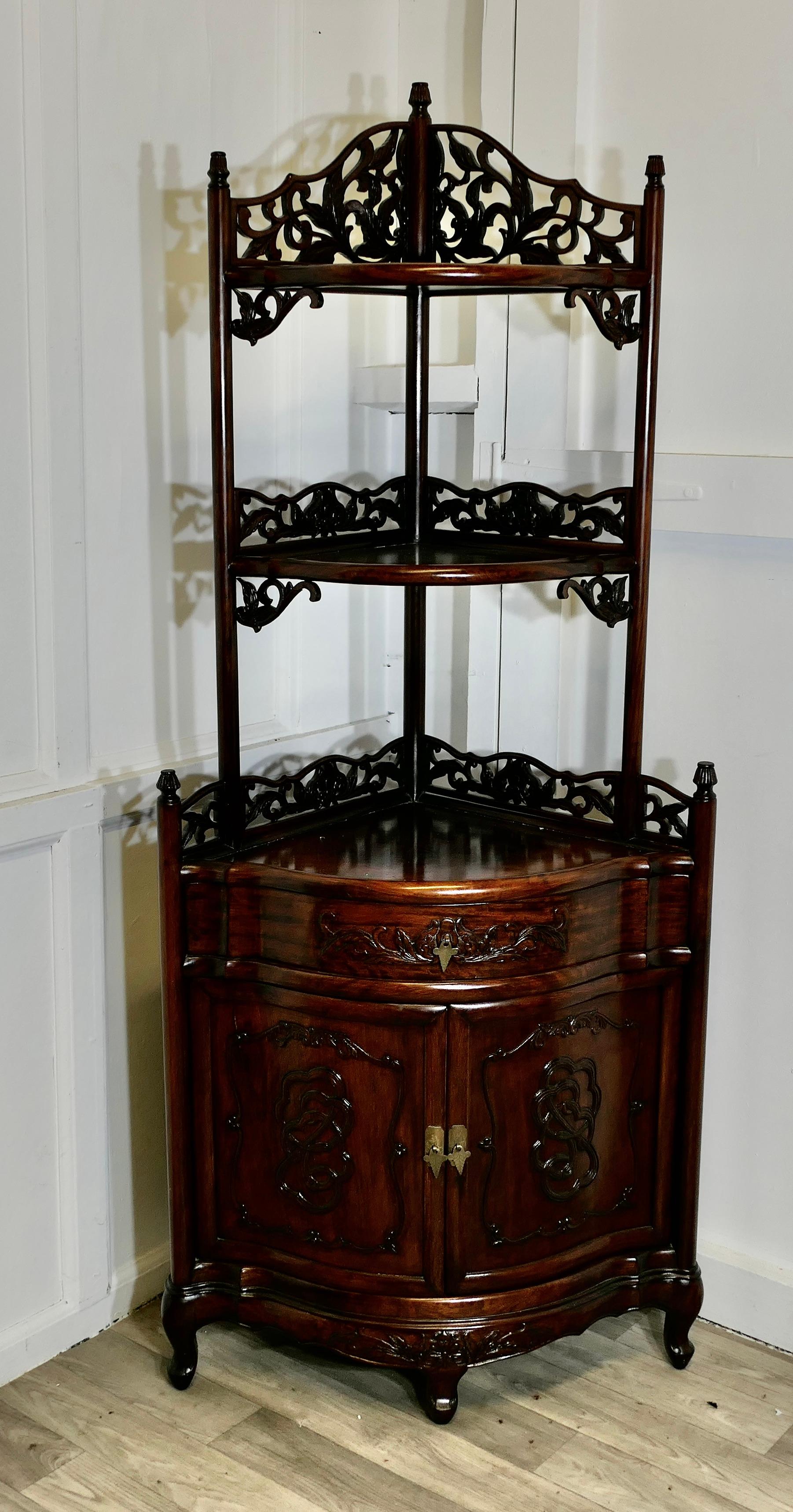 Étagère d'angle sculptée de style oriental avec armoire et tiroir

Une superbe pièce avec 3 étagères à galerie percée au-dessus d'un meuble à 2 tiroirs à façade en arc et d'un tiroir.
Les galeries sculptées présentent un délicat motif de feuilles,