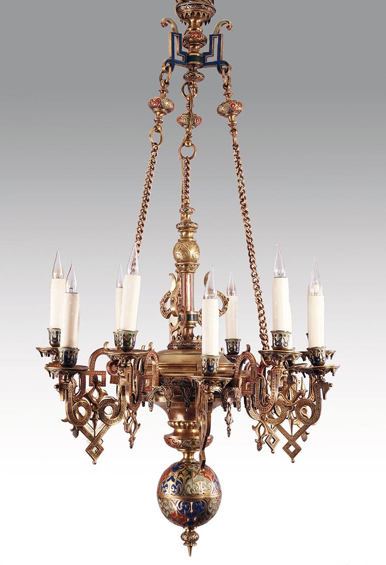 Oriental style twelve arms chandelier with very fine geometric motifs of polychrome cold enamel on bronze. Suspended by three chains, it is centered by an ornamentation of tracery and stylized diamond-shapes. Twelve sconces and their assorted basins