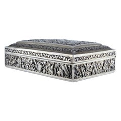 Oriental-style silver jewelry box with raised plant motifs and hinge