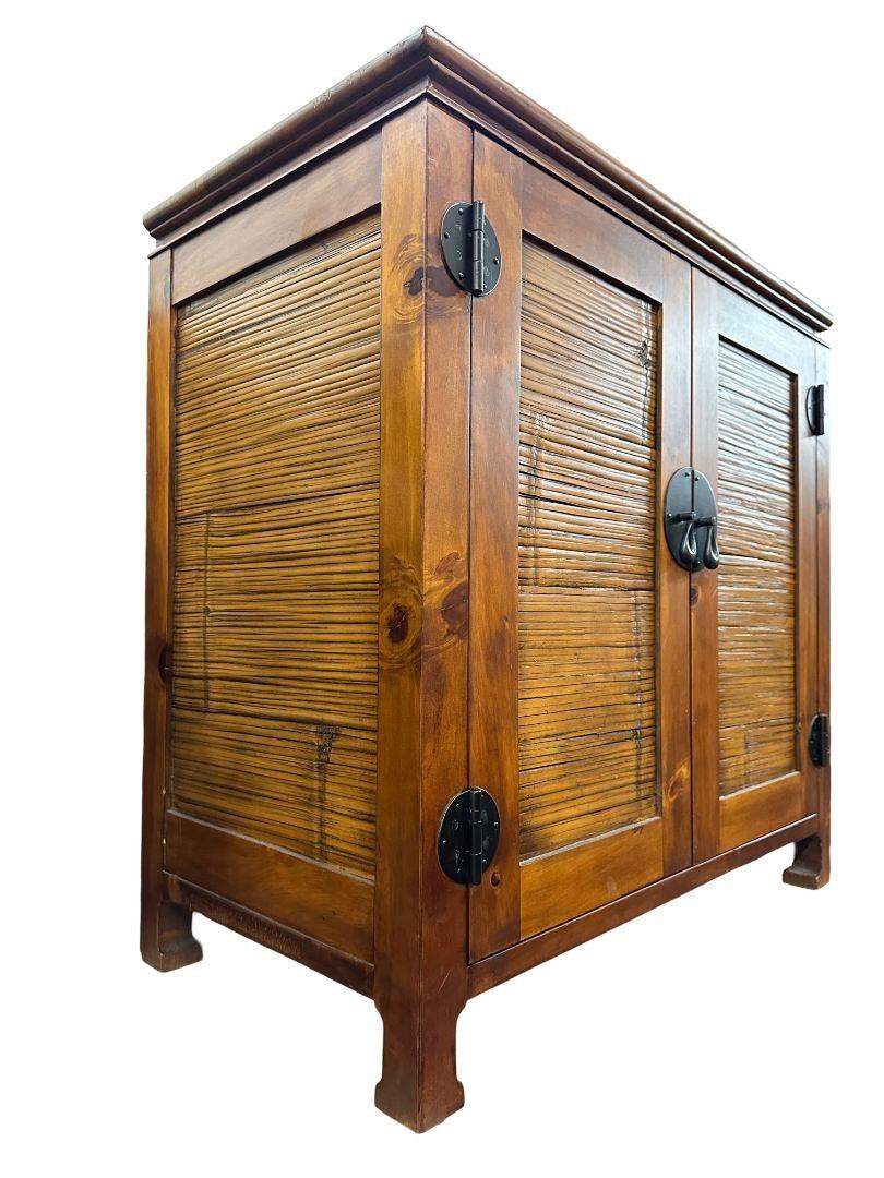 The oriental style wood and rattan cabinet seamlessly fuse traditional craftsmanship with contemporary design. Crafted from quality wood and adorned with intricate rattan detailing, it offers ample storage for media essentials while adding an