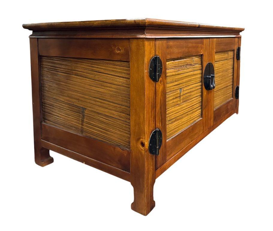 The Oriental Style Wood and Stick Rattan TV Console offers a blend of elegance and functionality. Crafted with fine wood and intricately woven rattan accents, it brings a touch of Eastern charm to any living space. With ample storage for media