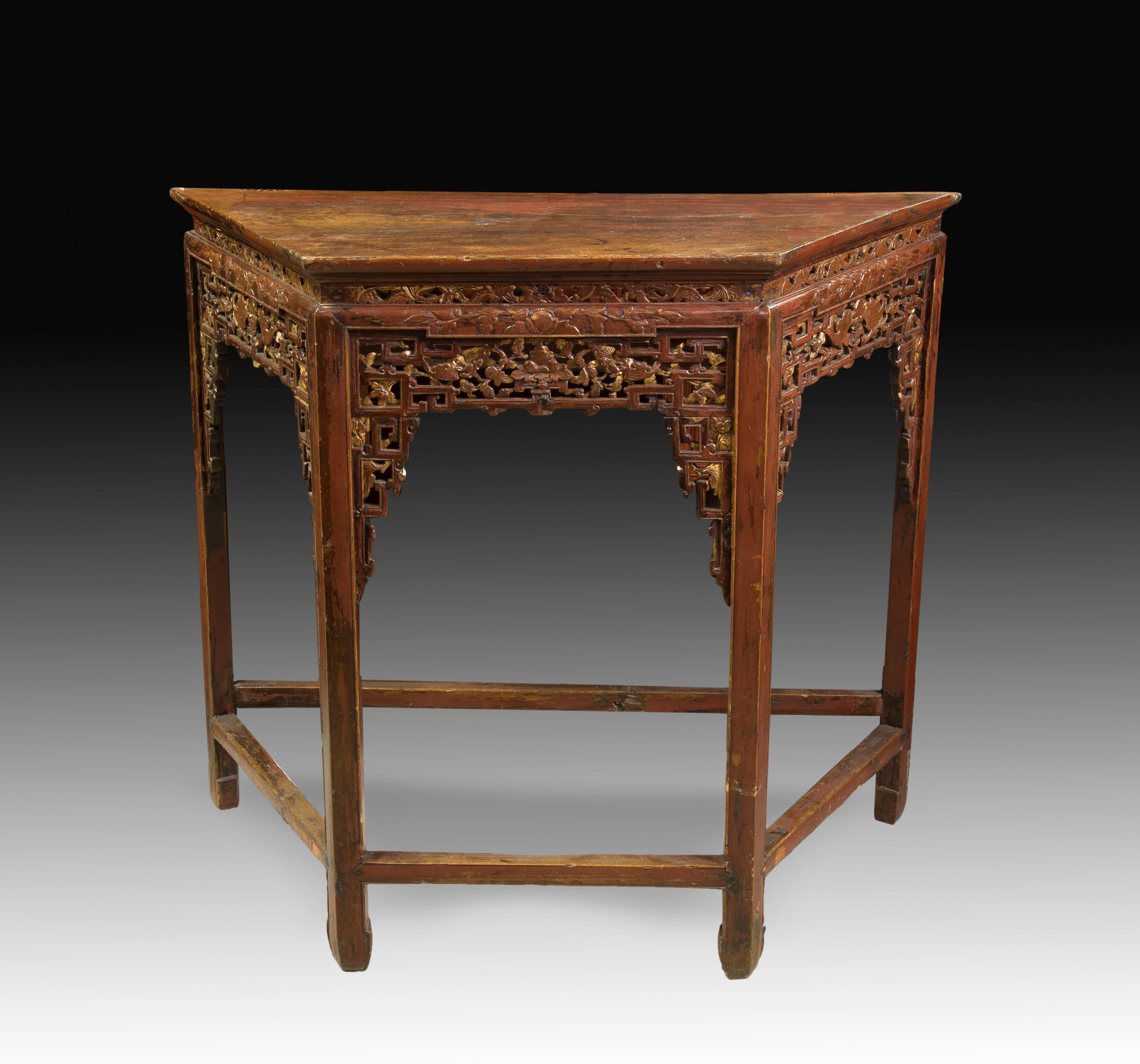 Smooth square table inspired by ancient Chinese art in its shape, legs and chambranas and, above all, in the decoration carved on the three front fronts of the same, perforated and based on geometric shapes and plant elements, keeping some of the