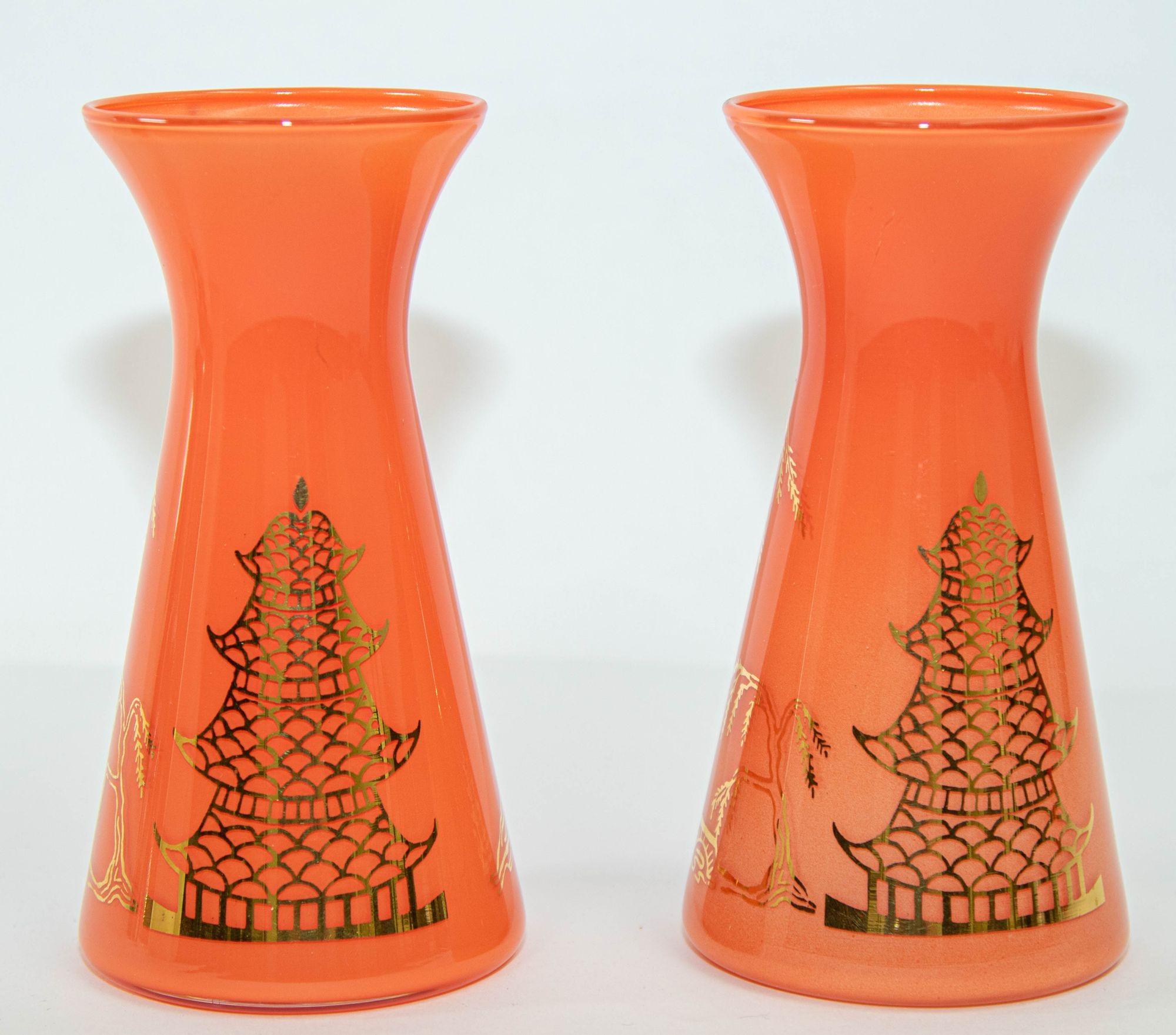 Vintage midcentury Oriental Orange Vases Set of 2 with Gold Asian Design.
Gay Fad style hand painted pair of bud glass vases in bright orange, coral color with gold designs Asian trees and pagodas.
Dimensions: 6 in H x 3.25 in D. at base, Top
