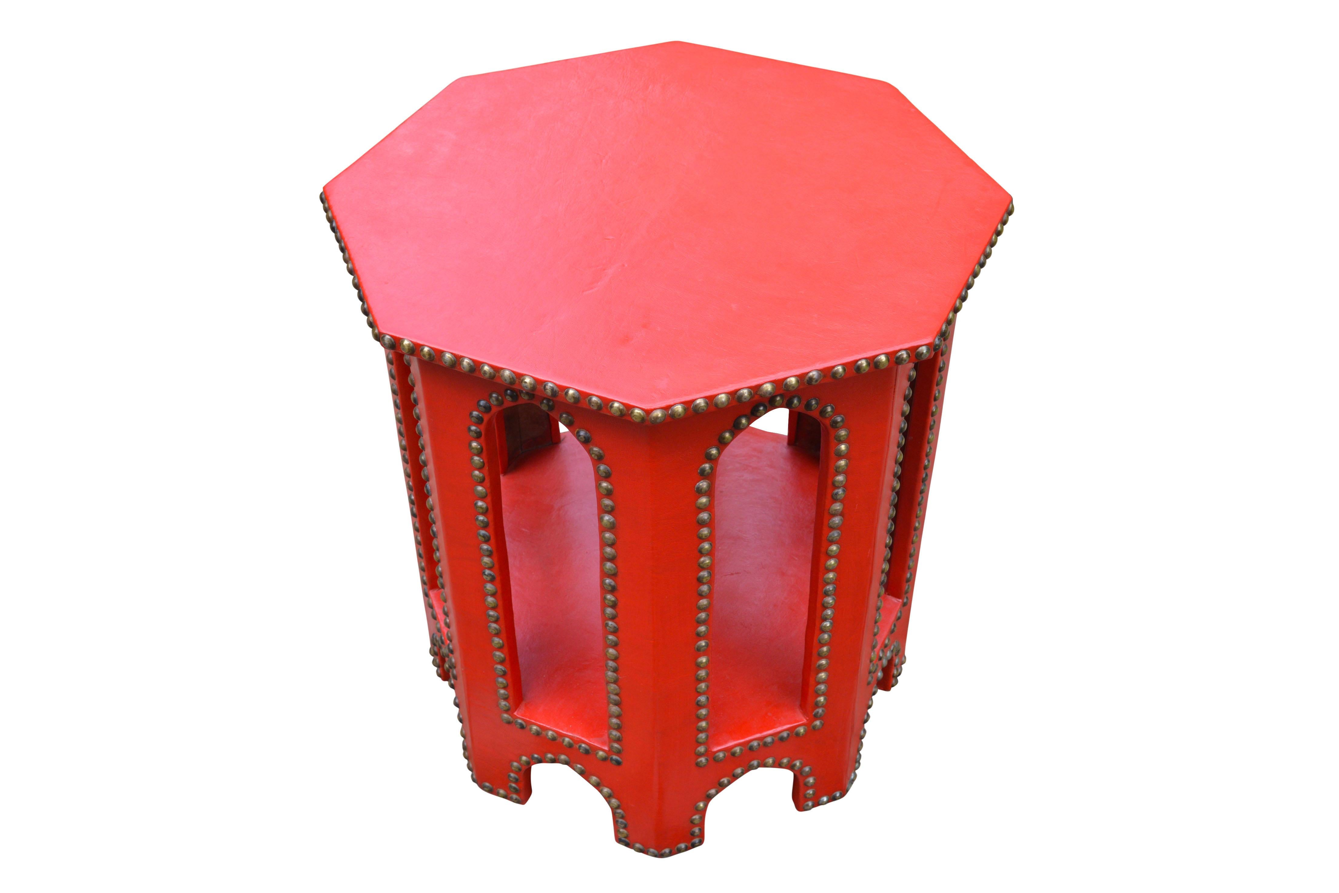 Delightful octagonal tea table in oriental style with characteristic ottoman arches. Covered in red leather with a beautiful patina and brass stud outlining’s.