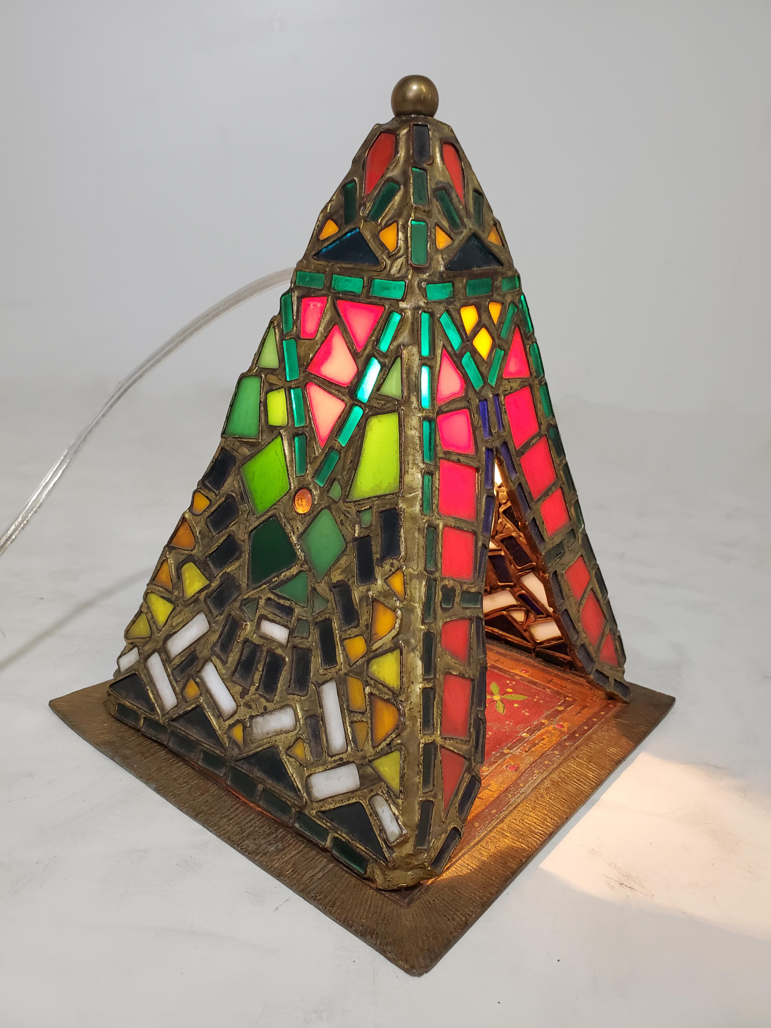 A charming Middle Eastern theme decorative table lamp / night light in leaded glass and cold painted French metal. Highly atmospheric with a soft glow and deep rich colors, the mosaic like tent illuminates to display a man smoking a pipe while