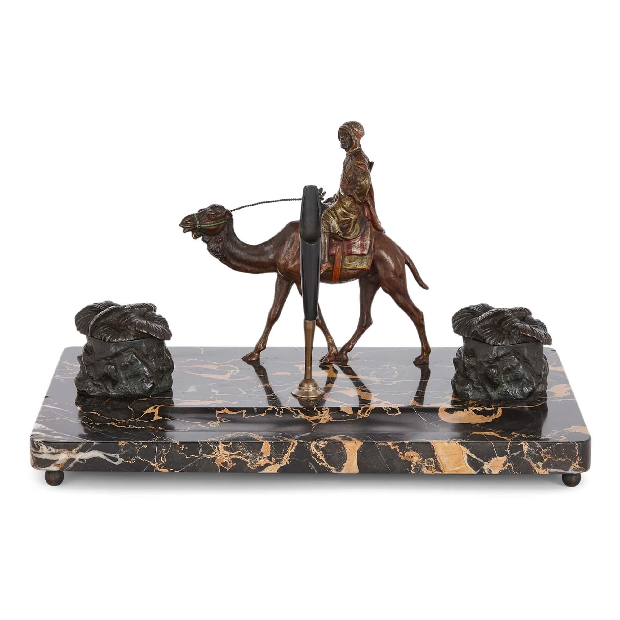 Orientalist cold-painted bronze and marble inkstand
Austrian, c. 1910
Height 21cm, width 34.5cm, depth 22.5cm

This unusual inkstand combines cold-painted bronze elements with a beautiful marble base. The centrepiece of the design is a figural
