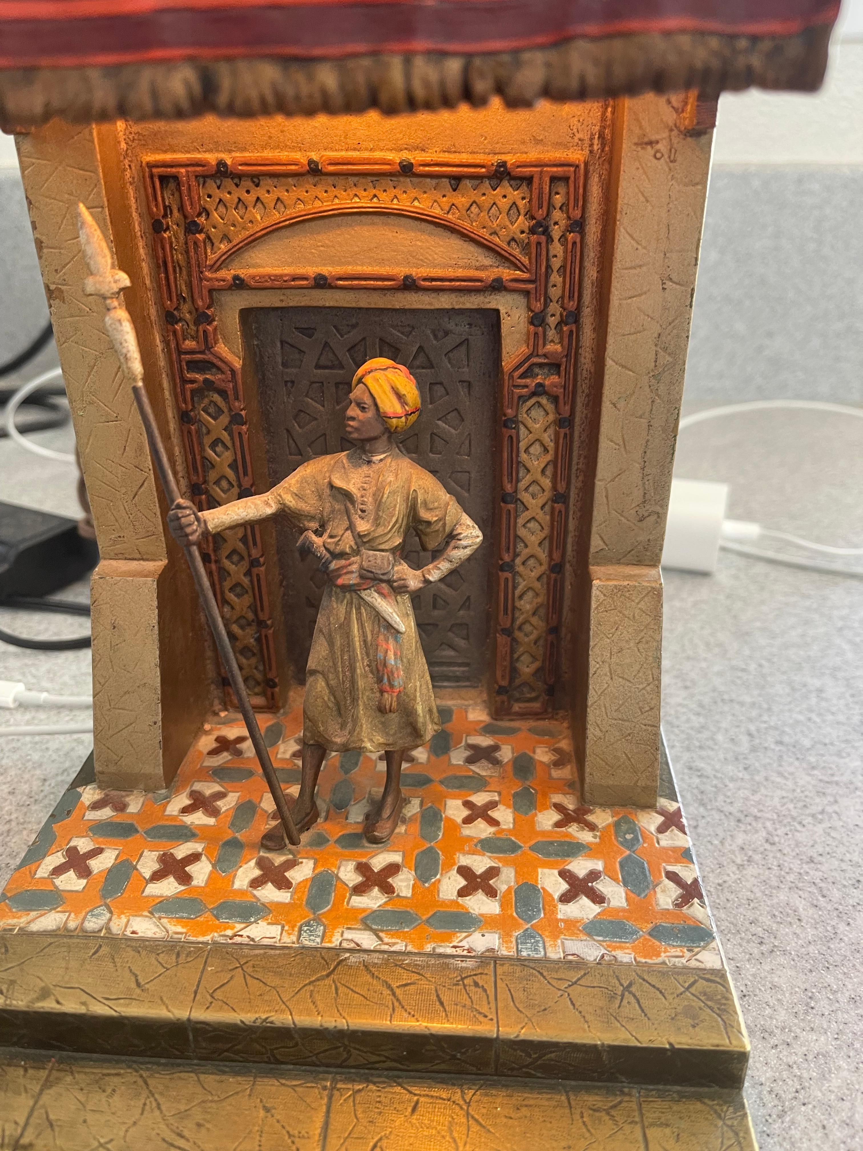 This highly detailed and colorful Vienna bronze lamp depicts a guard standing and protecting the palace. The colorful canopy and floor are just 2 of the many features that makes this one special. Artist signed 