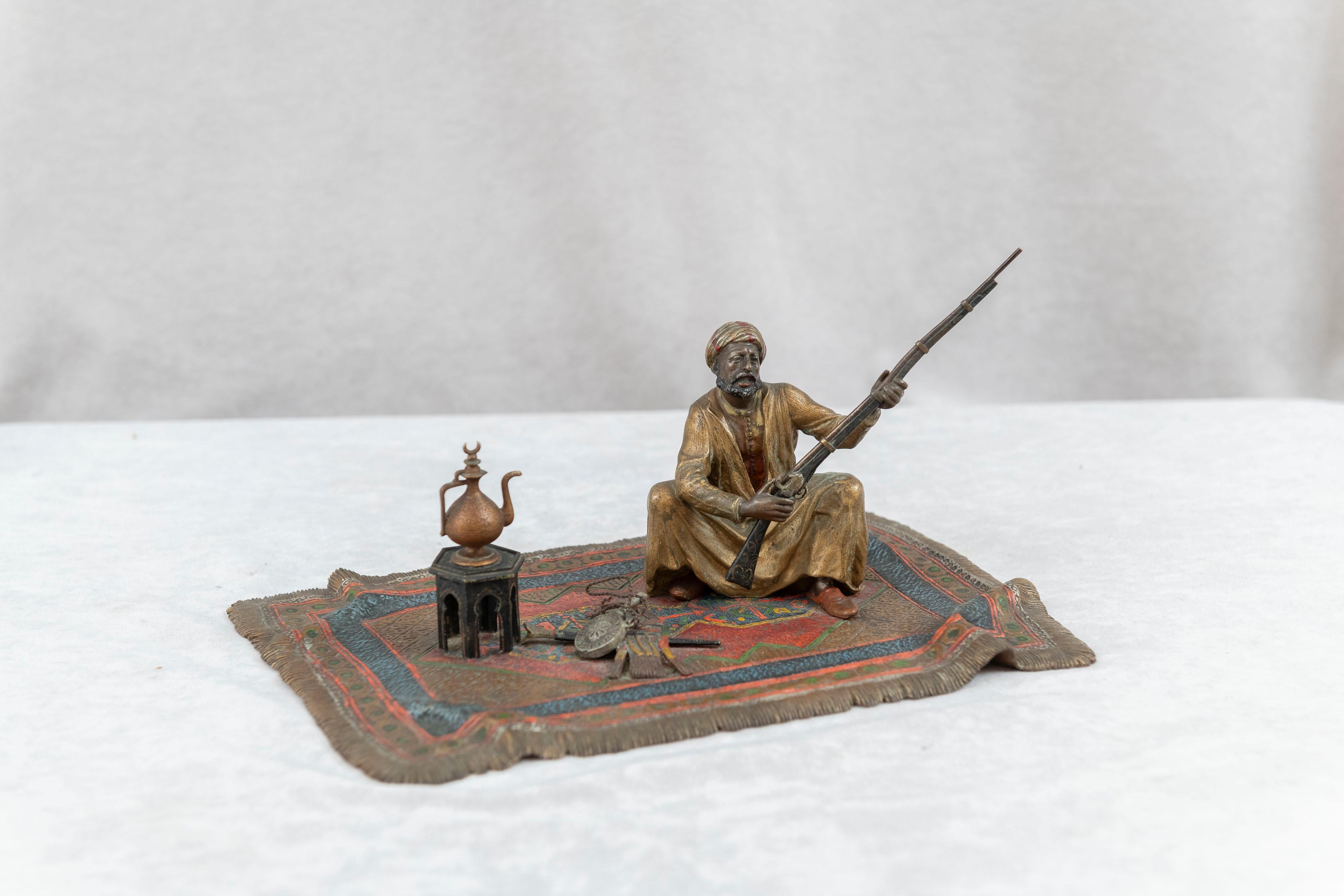  This cold painted bronze is larger than usual for this subject matter. The man sitting on a large rug and holding a rifle shows off the work of Franz Bergmann. Meticulously painted and detailed casting are what he was known for. An early example of