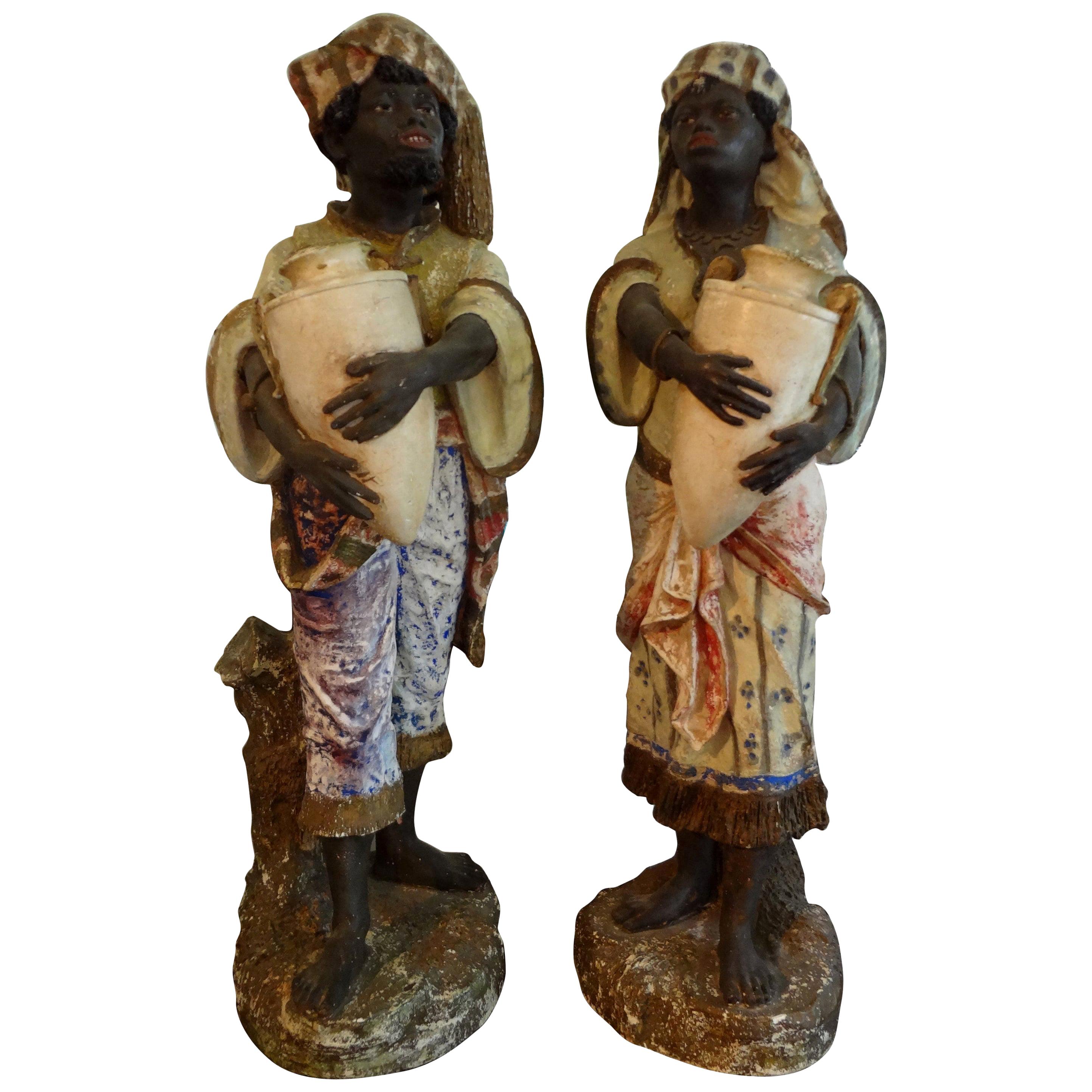 trio of golden elepants holding a glass ball figure in plaster