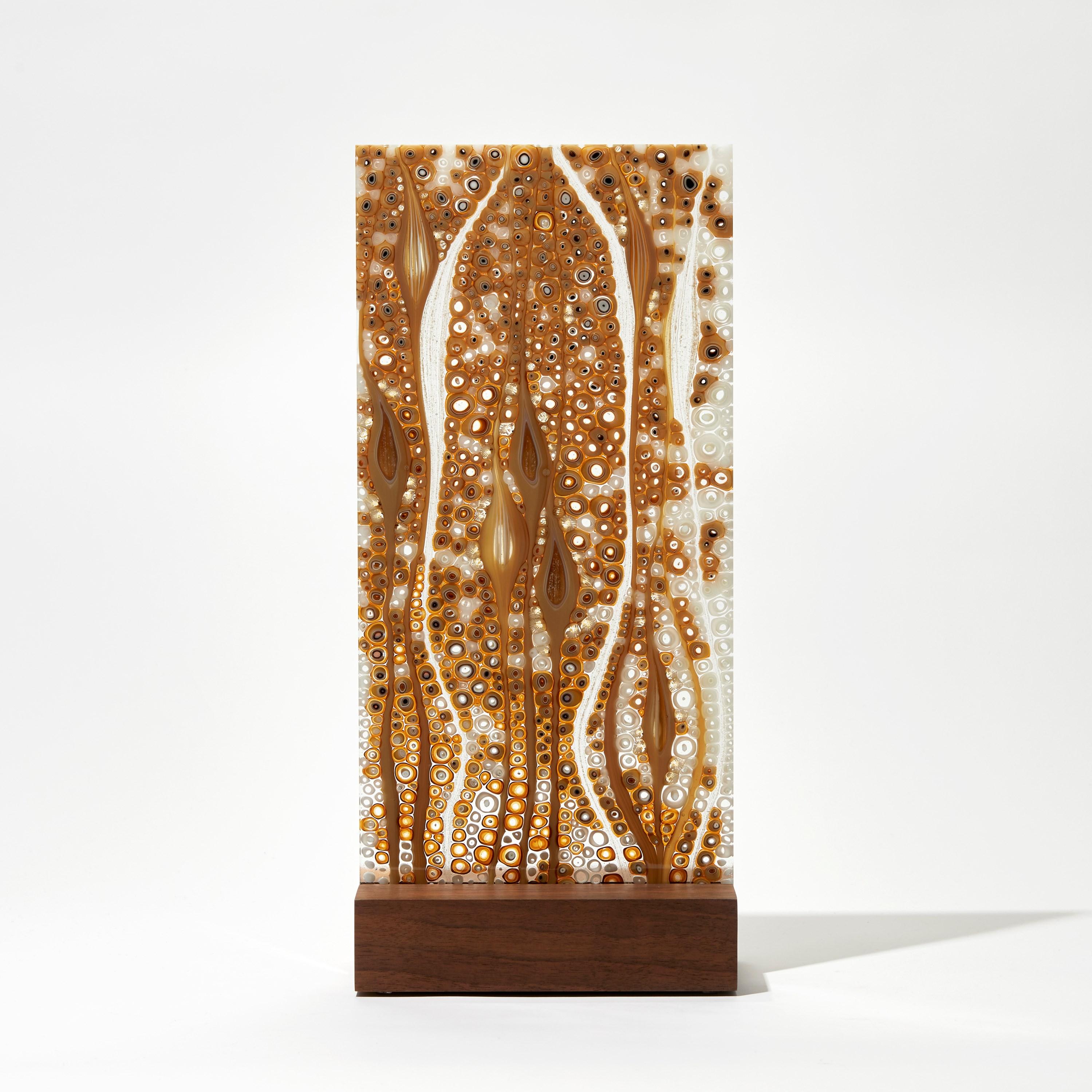 'Orientation in Gold No 4' is a unique glass sculpture by the Austrian artist Sandra A. Fuchs, created in amber, white and clear glass. 

Fuchs creates her own multicoloured and complex glass canes, which are then cut to create small 'murrina'.