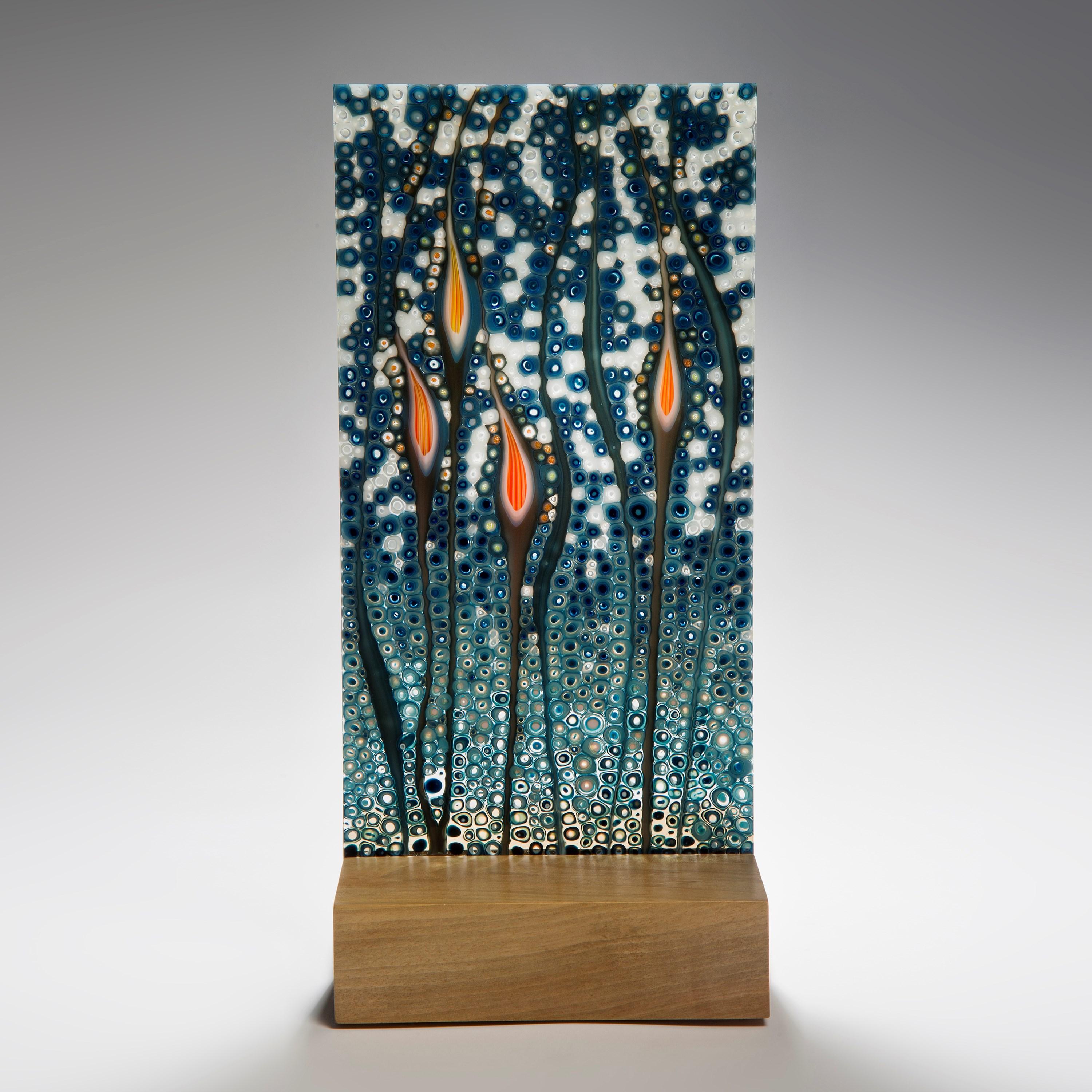 'Orientation in Petrol', is a unique glass sculpture by the Austrian artist Sandra A. Fuchs. Created in petrol blue, teal blue and vibrant orange glass. Fuchs creates her own multicolored and complex glass canes, which are then cut to create small