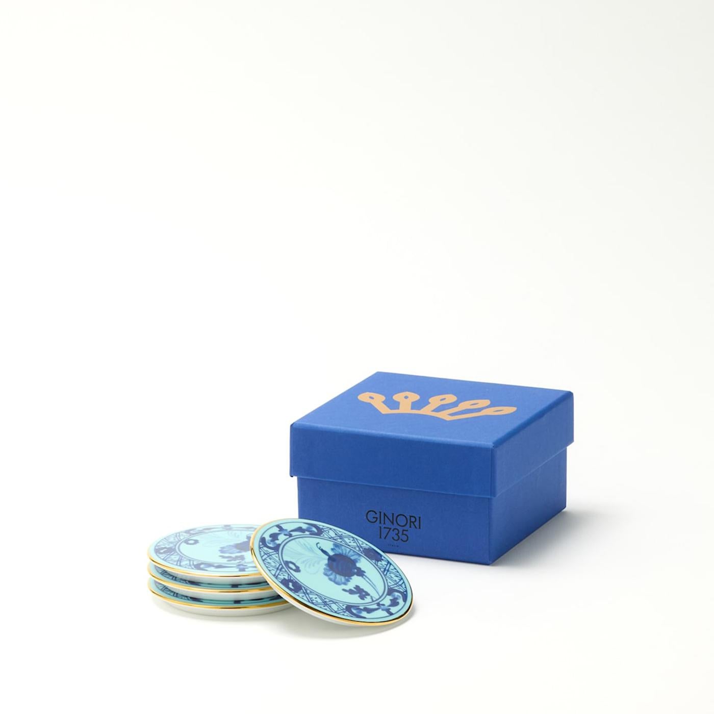 Set of 4 Iris porcelain coasters from Oriente Italiano Collection. This set of four floral motif coasters with The lustrous pure gold trim accentuates the beauty of the Iris blue decoration. From elegant outdoor cocktail parties to intimate dinners