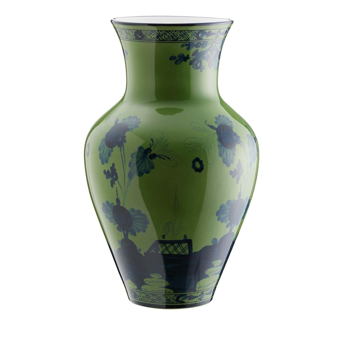 Part of the Oriente Italiano Collection, this Ming-style vase is crafted of porcelain and boasts the superb decoration. Its green background is adorned with a series of blue patterns, obtained with the precision of airbrush technique, that depict a
