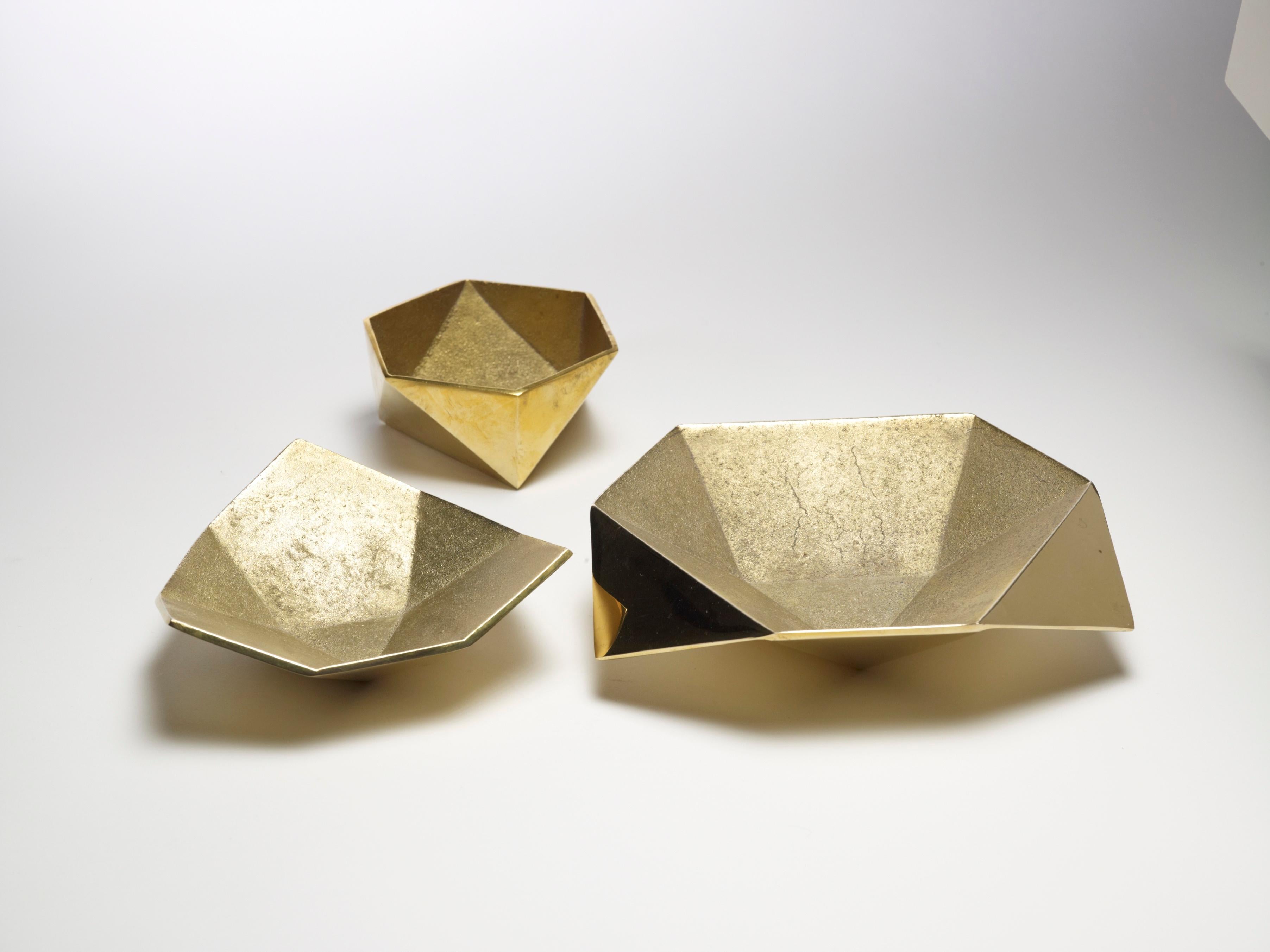 Diese gegossenen Metallgefäße sind den Origami-Formen nachempfunden. Erhältlich in Messing und Aluminium. Satz von drei.

AKMD wurde 2011 gegründet und entstand aus einer dreizehnjährigen Freundschaft und Design Collaboration zwischen Ayush Kasliwal