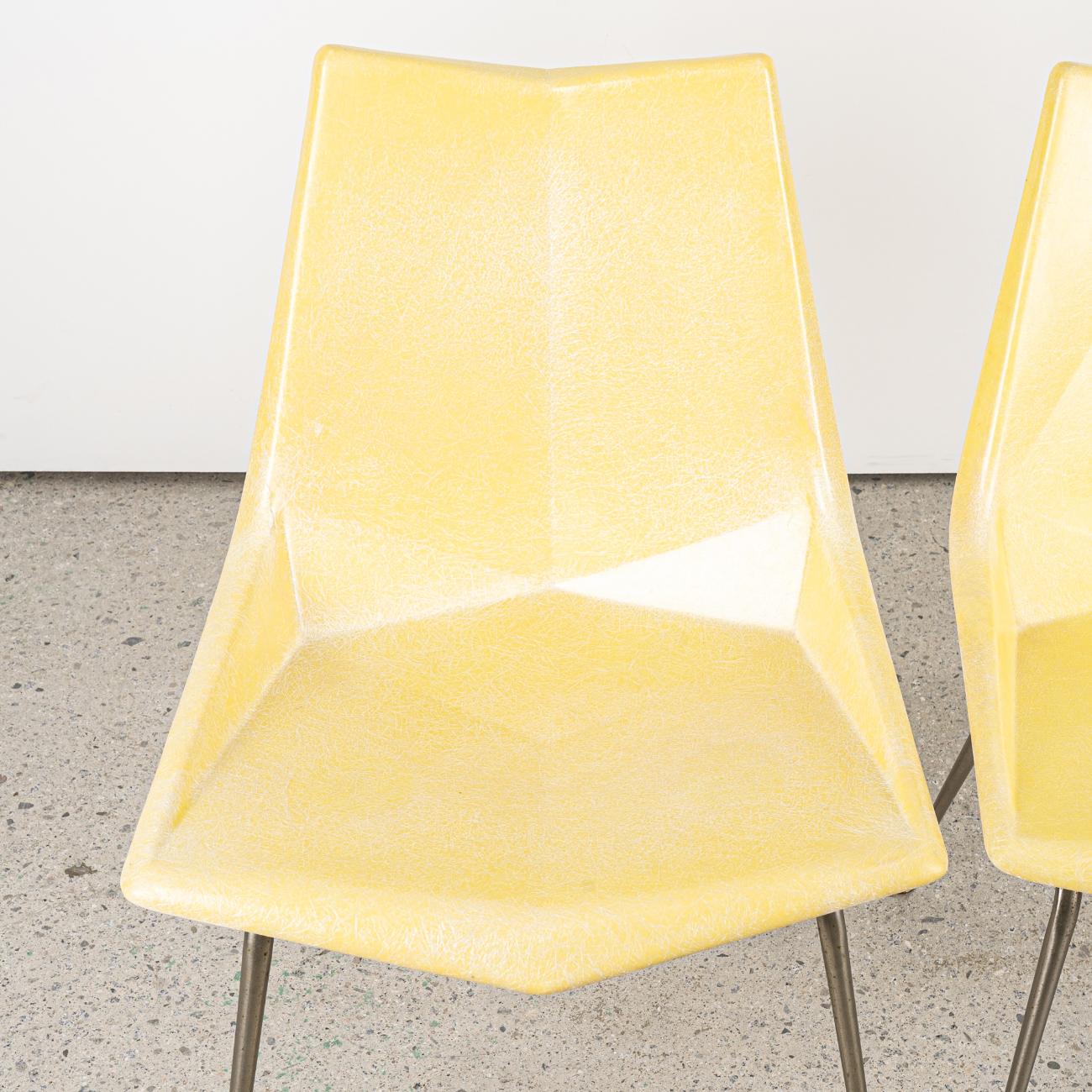 A 1950s Paul McCobb Origami chair for St. John. 
The fiberglass seat is molded at angles, reminiscent of the Japanese origami technique. 
Lemon Yellow fibreglass seat is in good vintage condition.
A faded but partially legible label is present