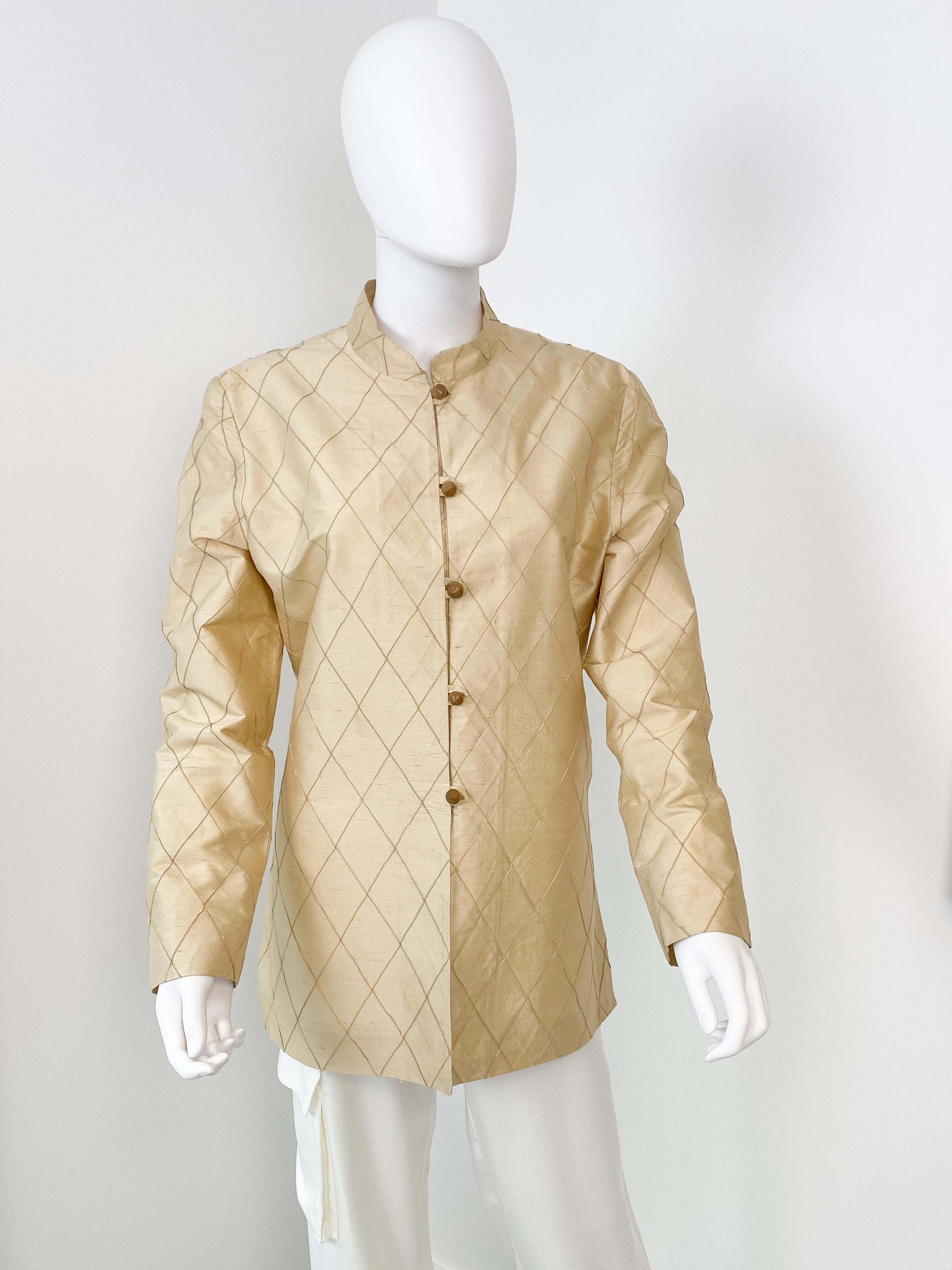 Cette veste en soie vintage d'inspiration asiatique des années 1980 présente un pli géométrique en origami sur une soie mélangée brute, des manches longues, une fermeture à bouton de bois sur le devant, un col mandarin Mao et de larges fentes sur